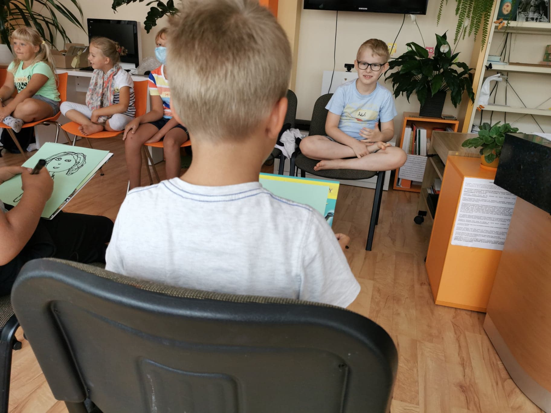 Dzieci pozujące do portertów podczas warsztatów w Pracowni Orange w Ryczywole.