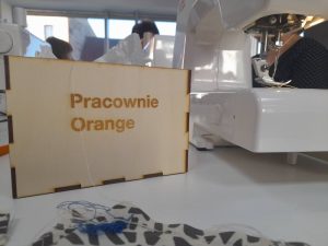 Napis Pracownia Orange na drewnianej tabliczce.