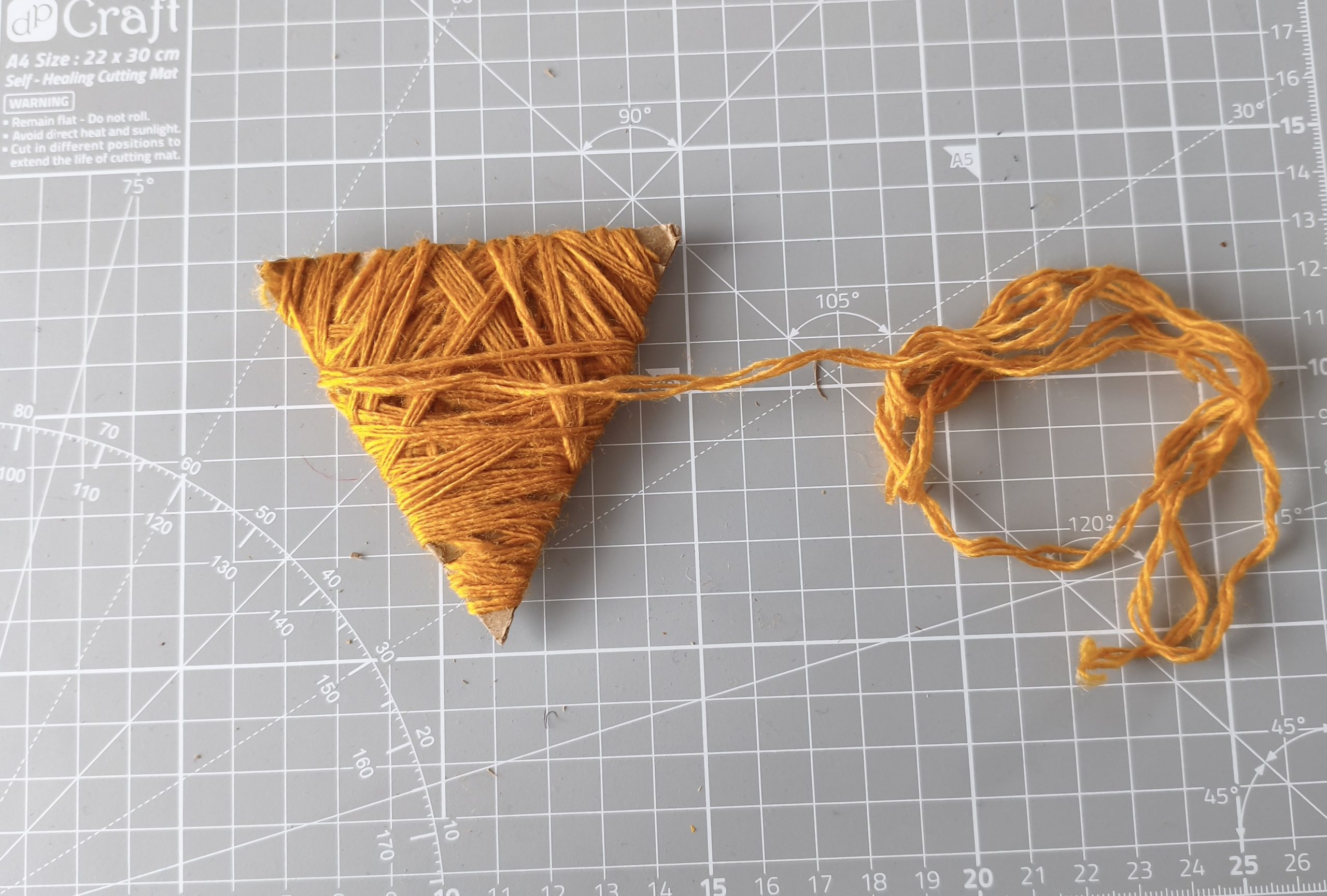 Głowa lisa wycięta z kartonu opleciona włóczką.