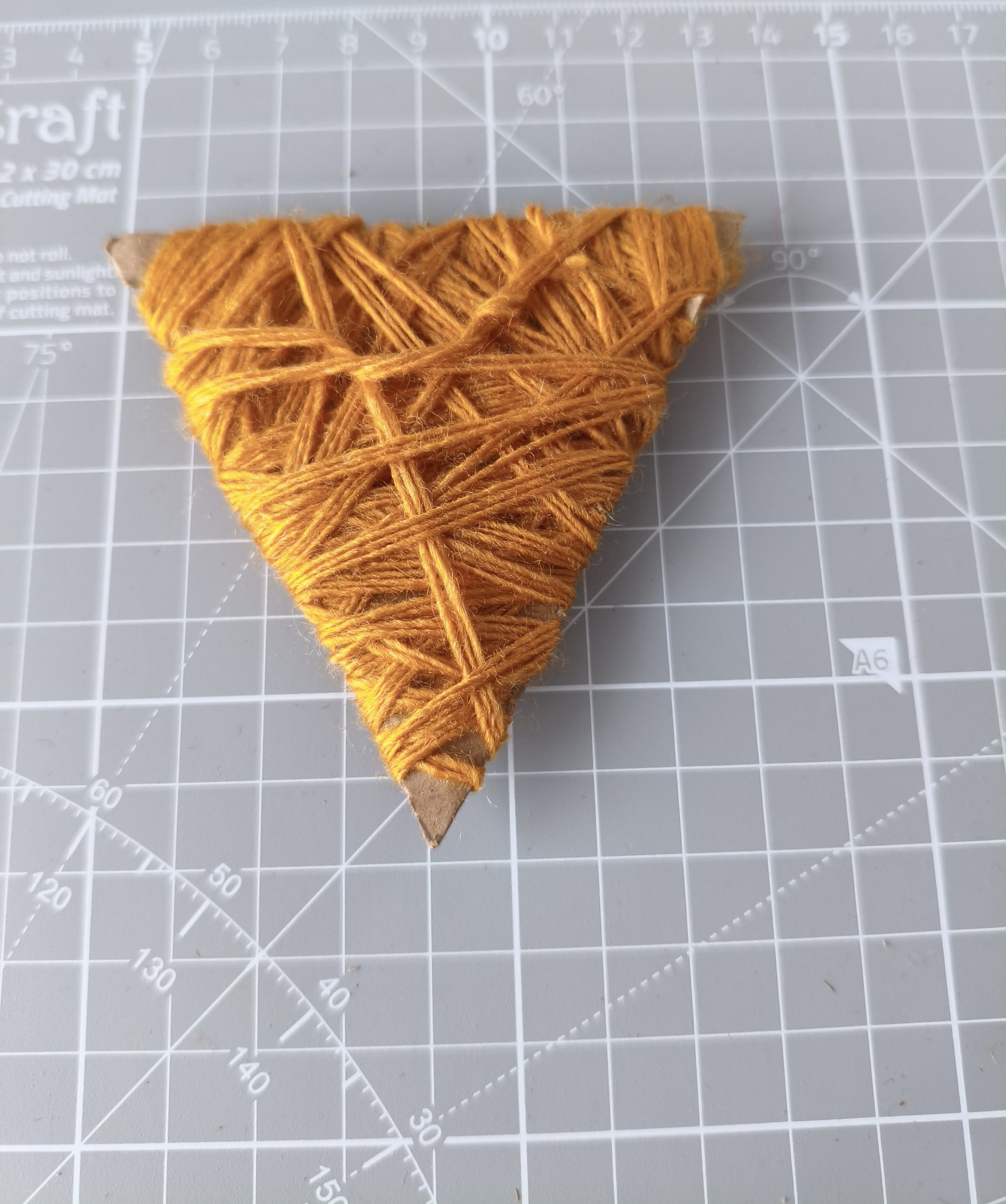 Głowa lisa wycięta z kartonu opleciona włóczką.