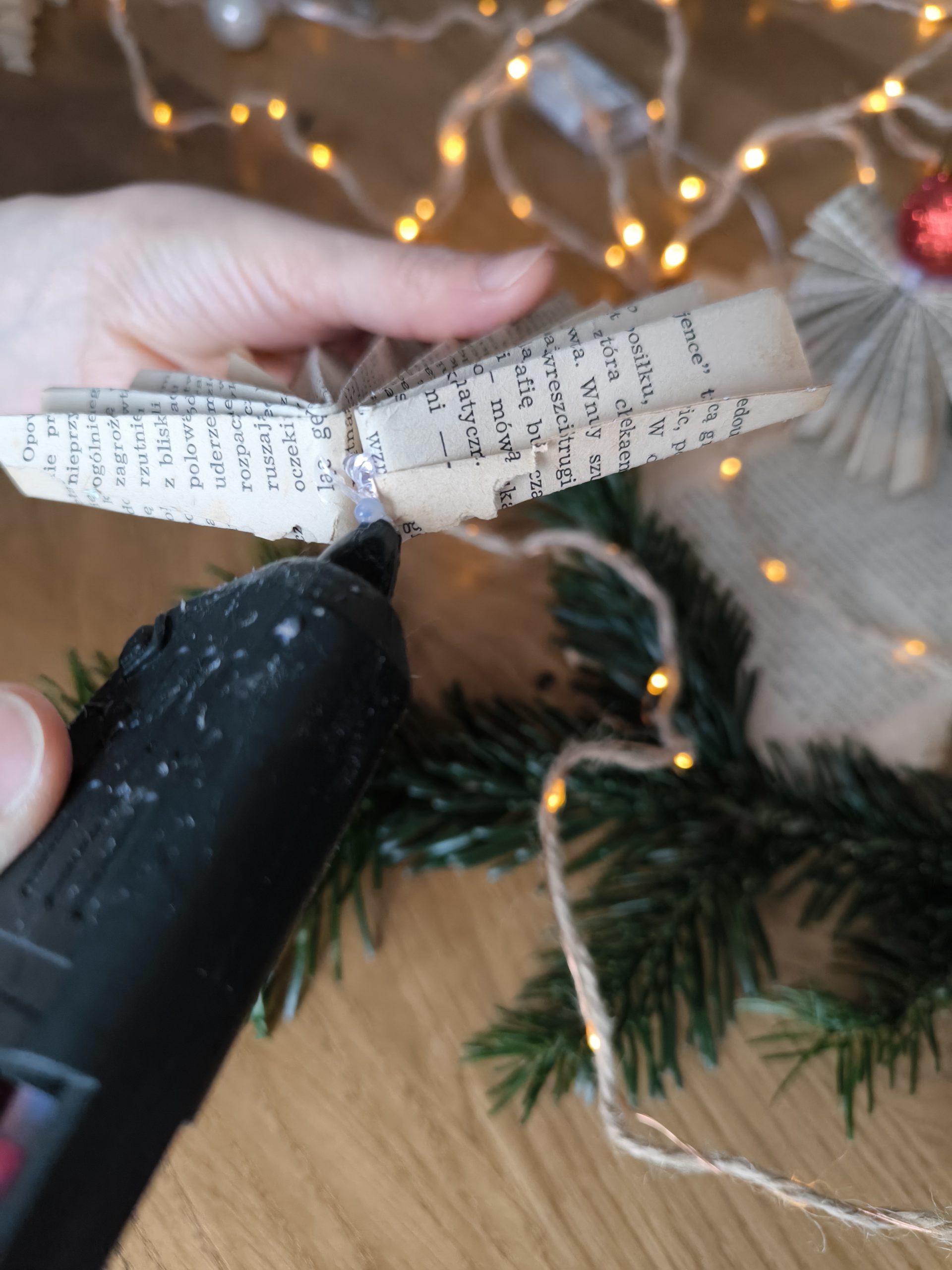 Zdjęcie przedstawiające moment klejenia klejem na gorąco fragmentów aniołka.