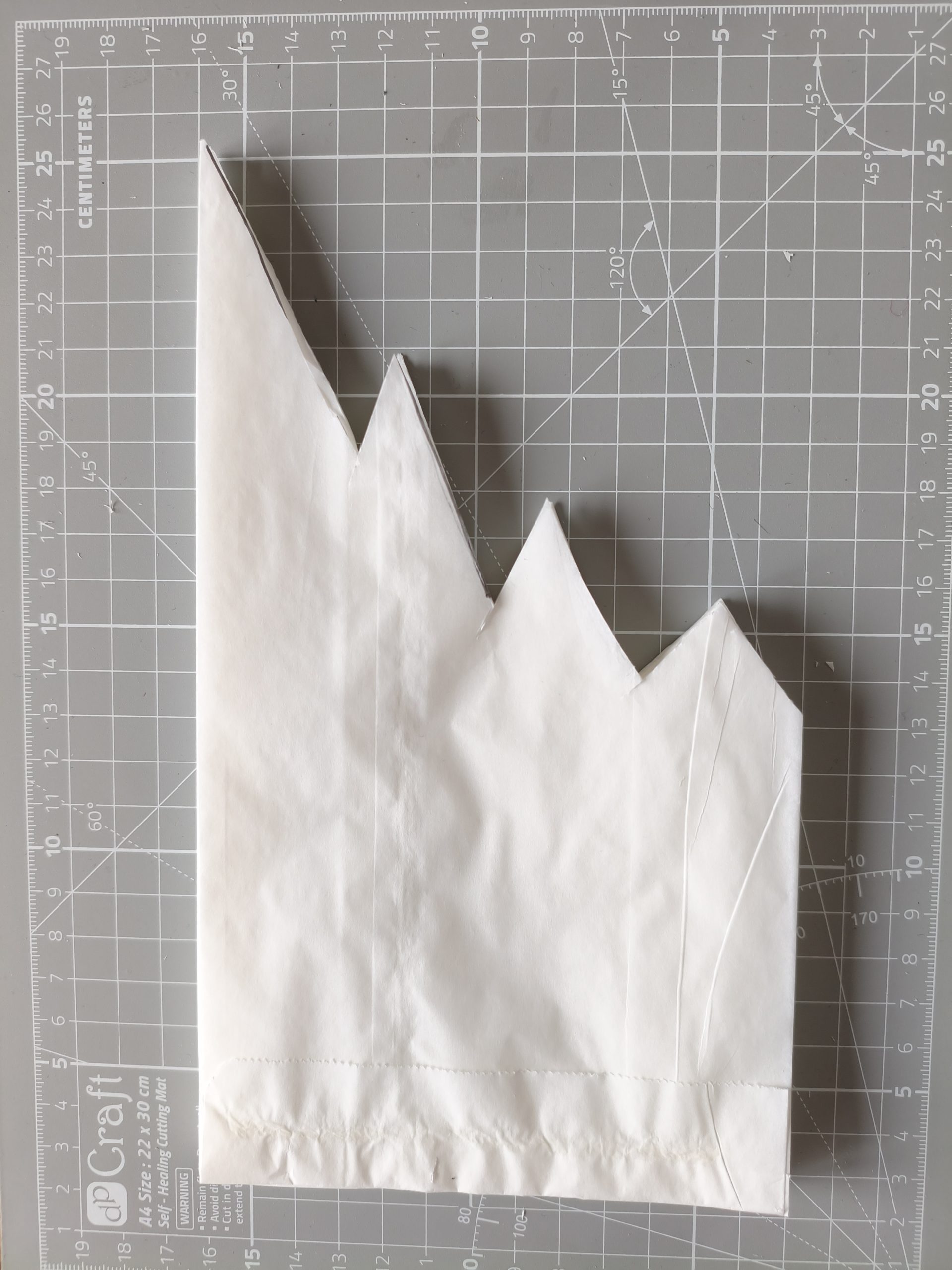 Fragment papierowej torebki z wyciętym fragmentem.