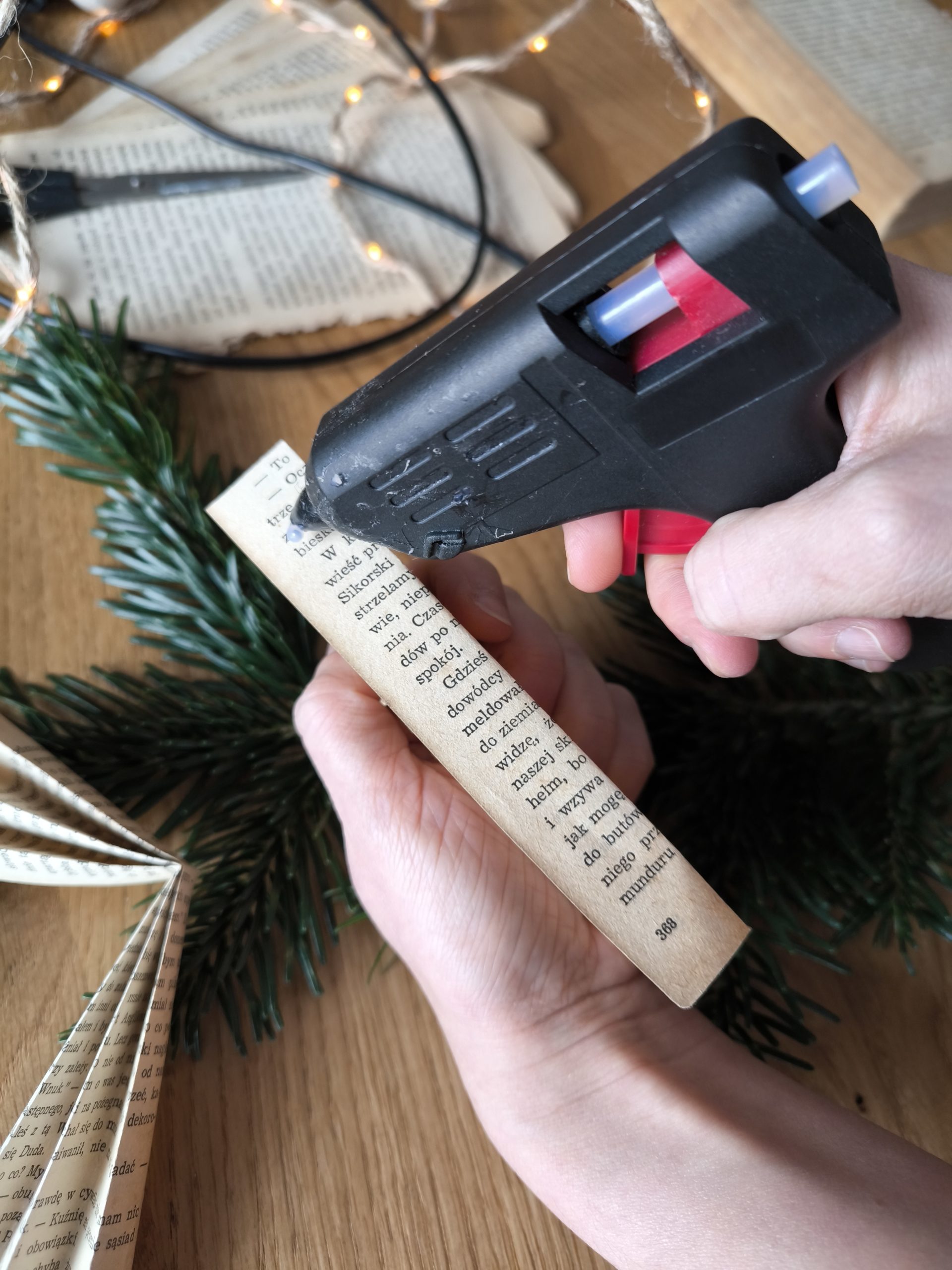 Zdjęcie przedstawiające moment klejenia klejem na gorąco fragmentów aniołka.