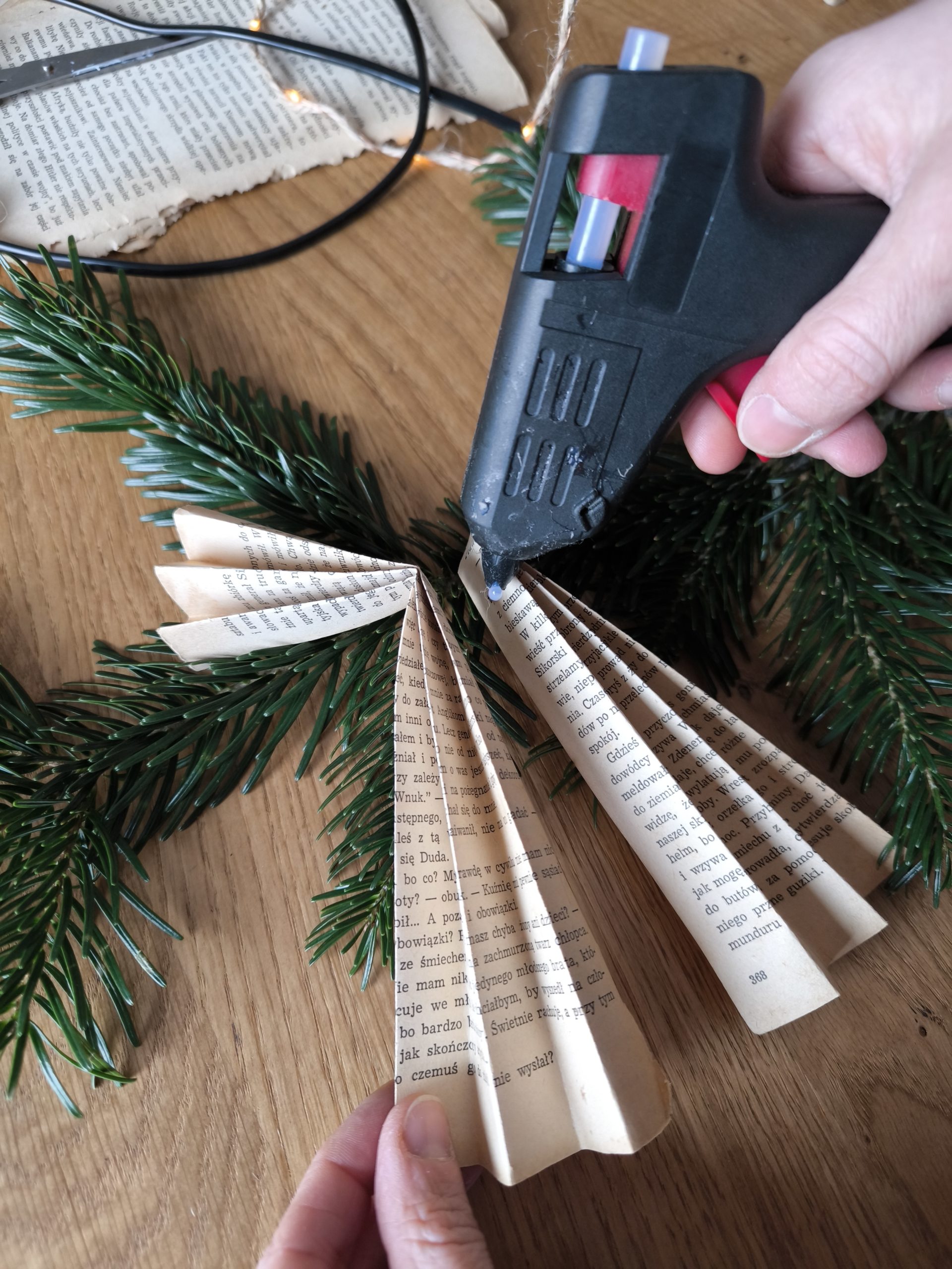 Zdjęcie przedstawiające moment klejenia klejem na gorąco fragmentów aniołka.