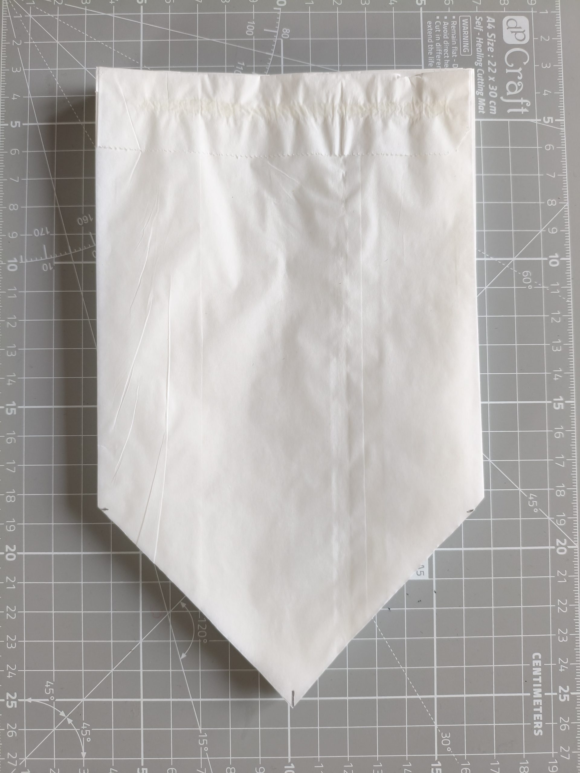 Fragment papierowej torebki z wyciętym fragmentem.