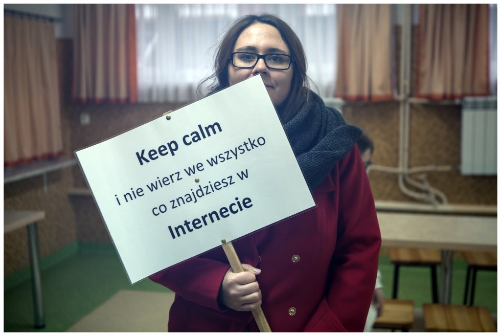 Kobieta trzymająca tabliczkę z napisem.