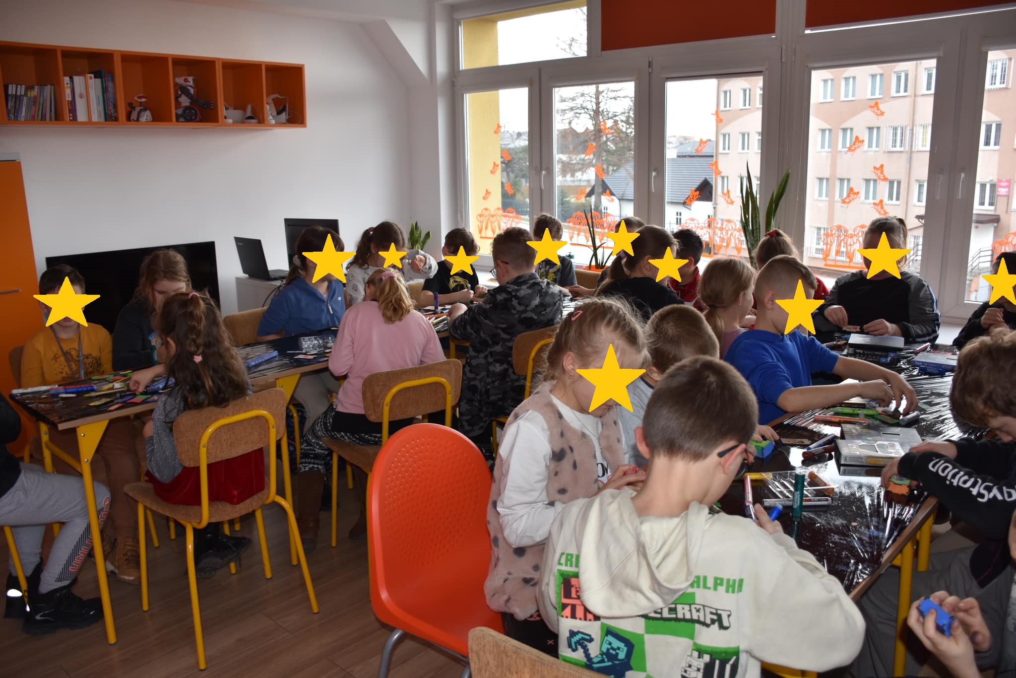 Dzieci siedzące przy stołach podczas warsztatów.