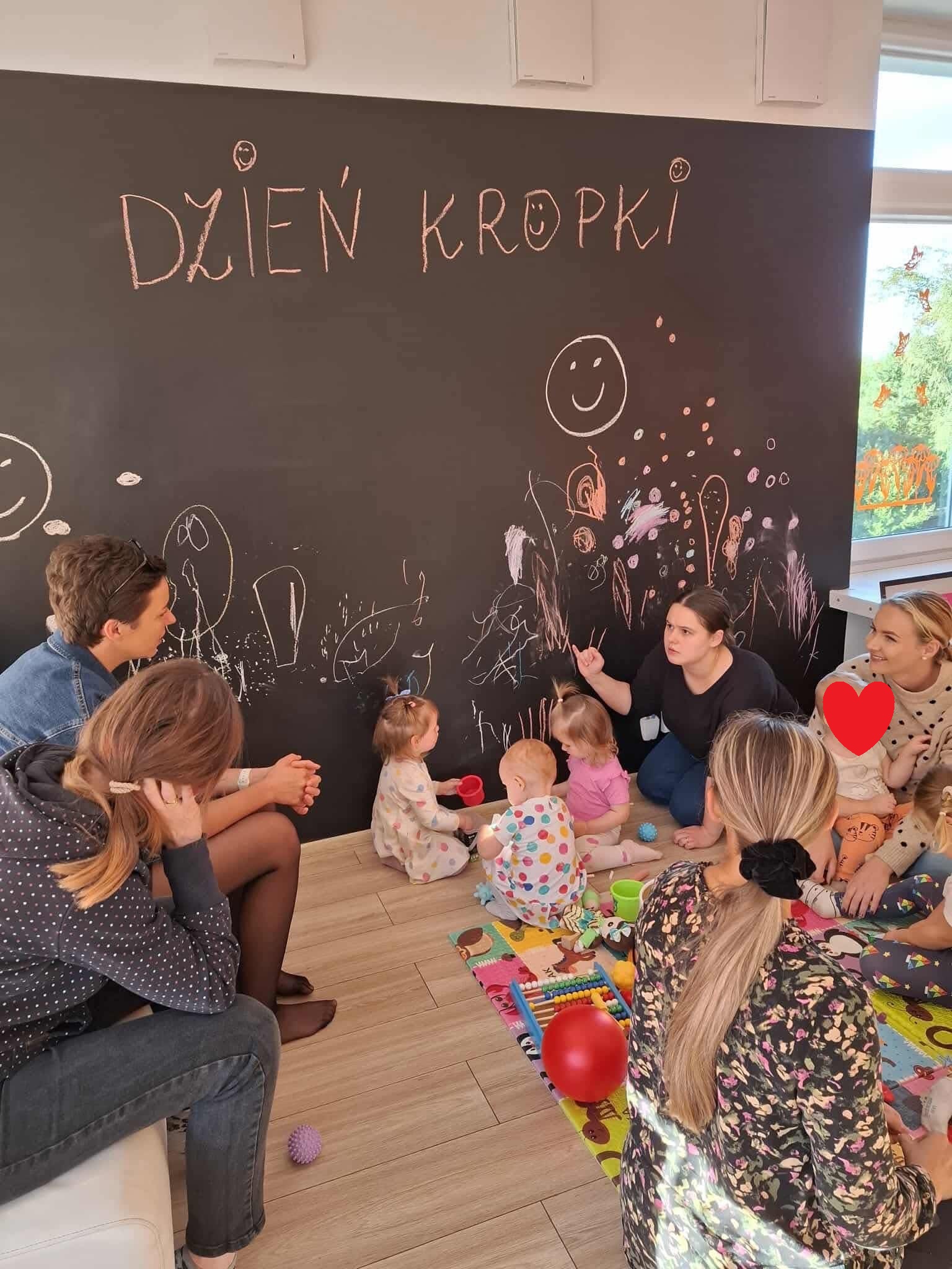 Grupa dzieci i ich mam wraz z prowadzącą DKK.