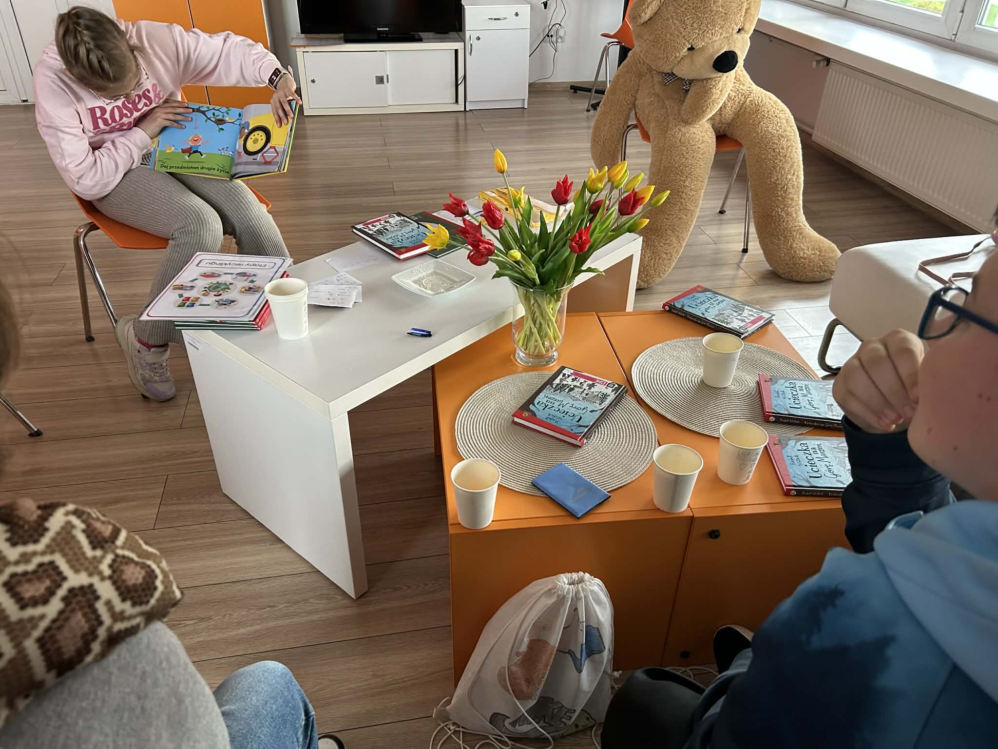 Miś siedzący przy stoliku z książkami