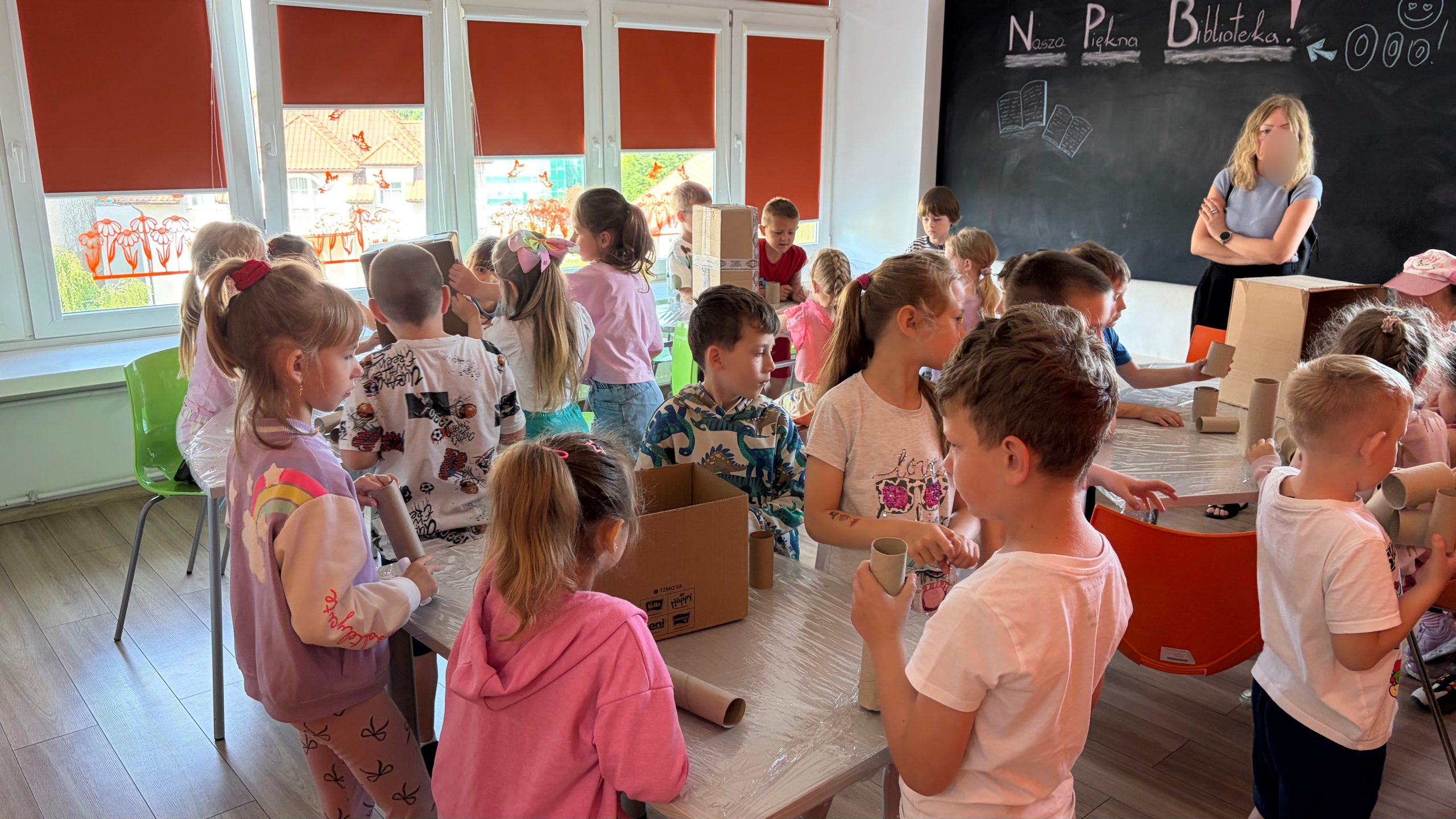 Grupa dzieci w Pracowni Orange czeka na rozpoczęcie warsztatów