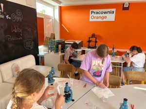 Dzieci w Pracowni Orange podczas obsługi mikroskopów.