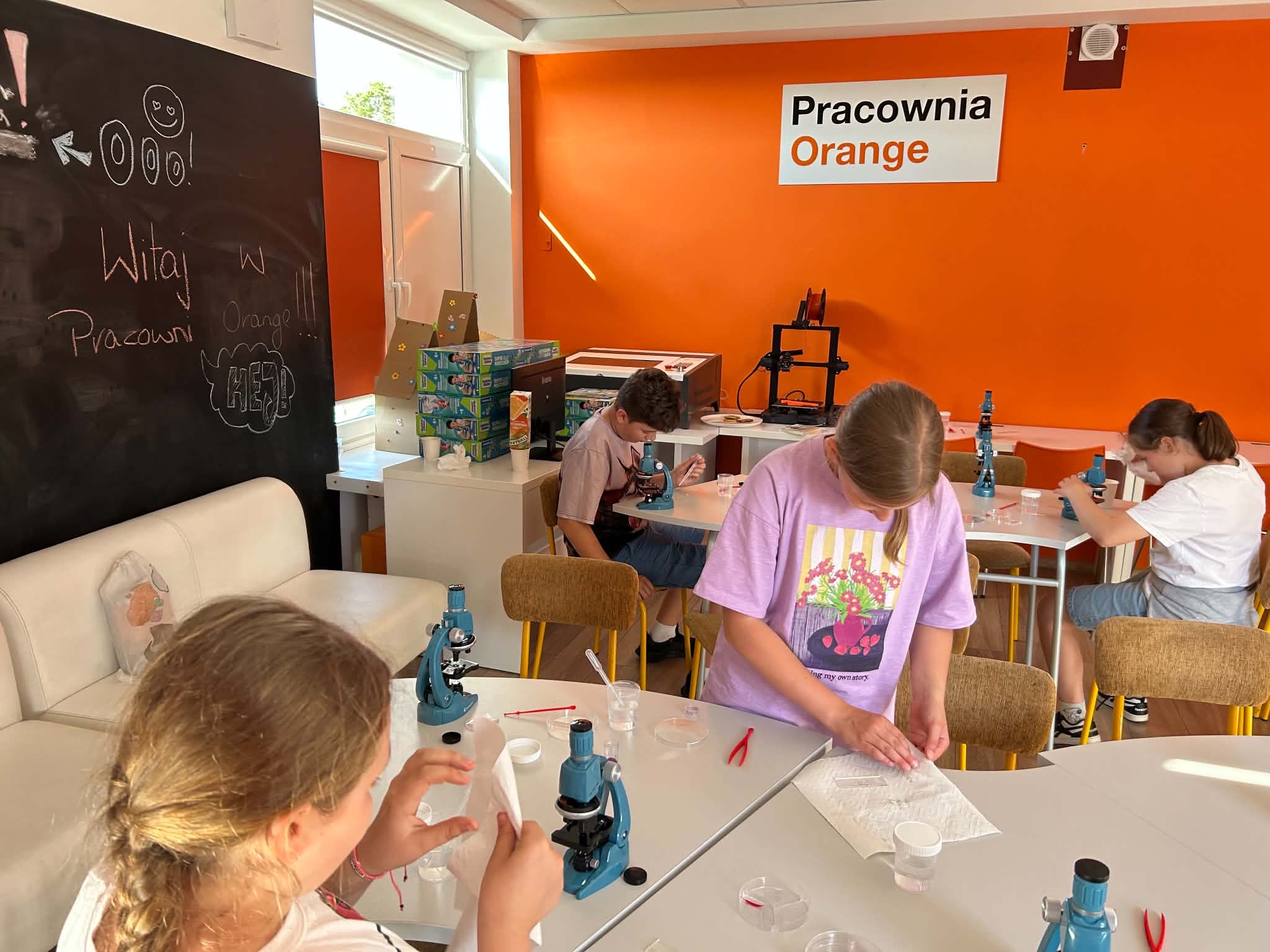 Dzieci w Pracowni Orange podczas obsługi mikroskopów.