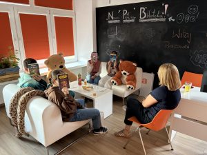 Grupa dzieci siedzi na kanapach w Pracowni Orange