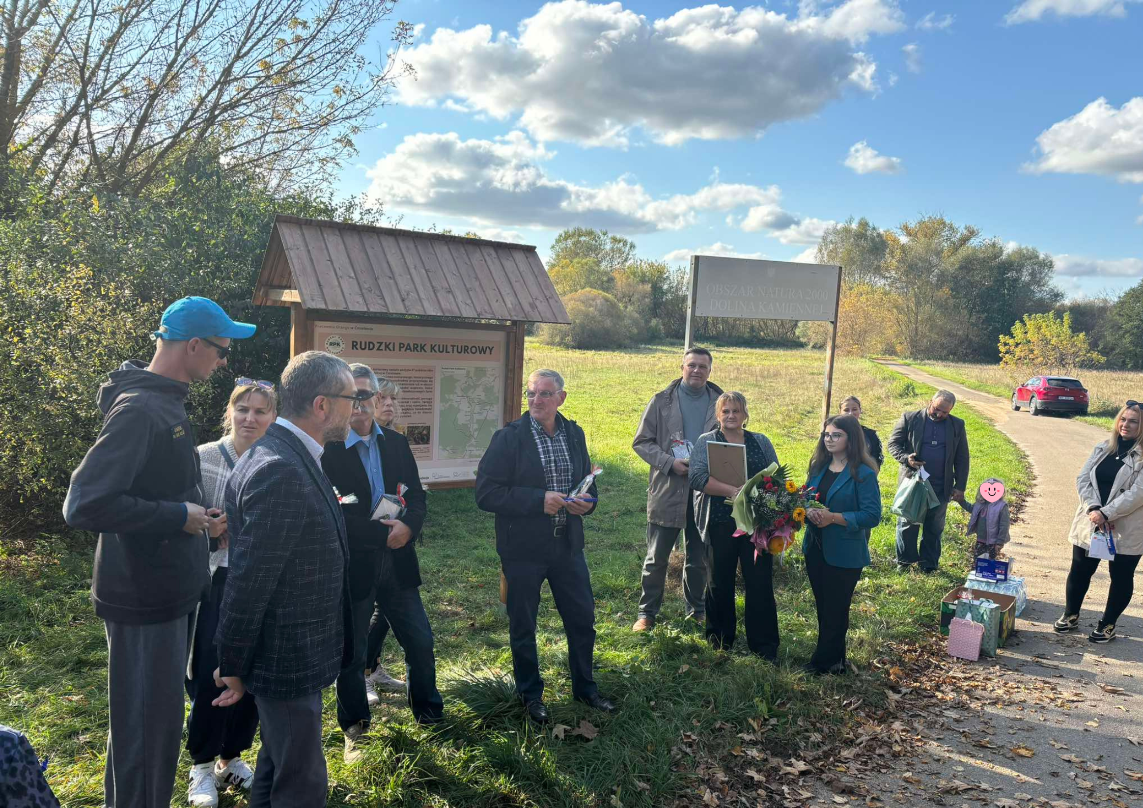 grupa osób przy tablicy Rudzki Park Kulturowy