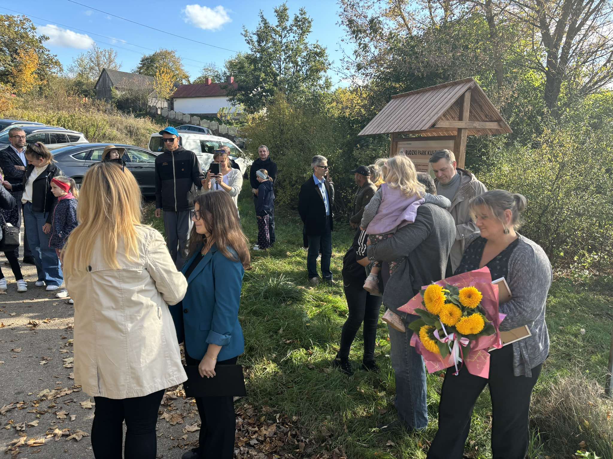 grupa osób na drodze przy lesie