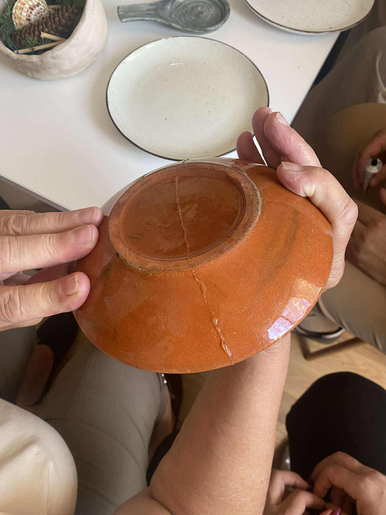 ręce kobiety formujące rzeźbę ze starej porcelany