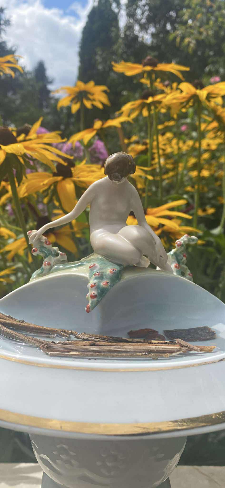 zdjęcie porcelany z rzeźbą kobiety na tle kwiatów