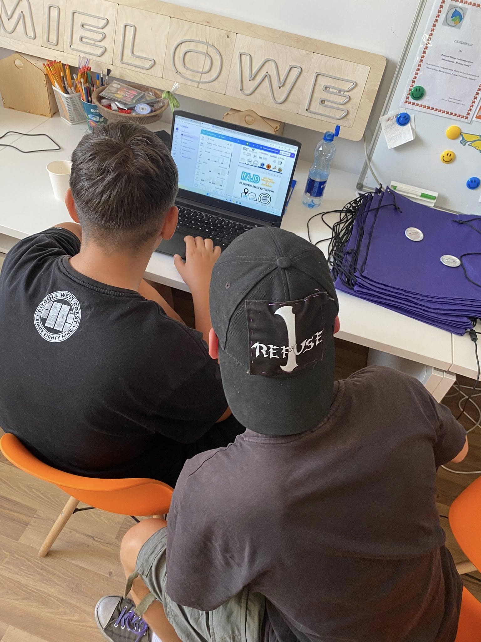 dwaj mężczyźni projektujący przy laptopie nadruki