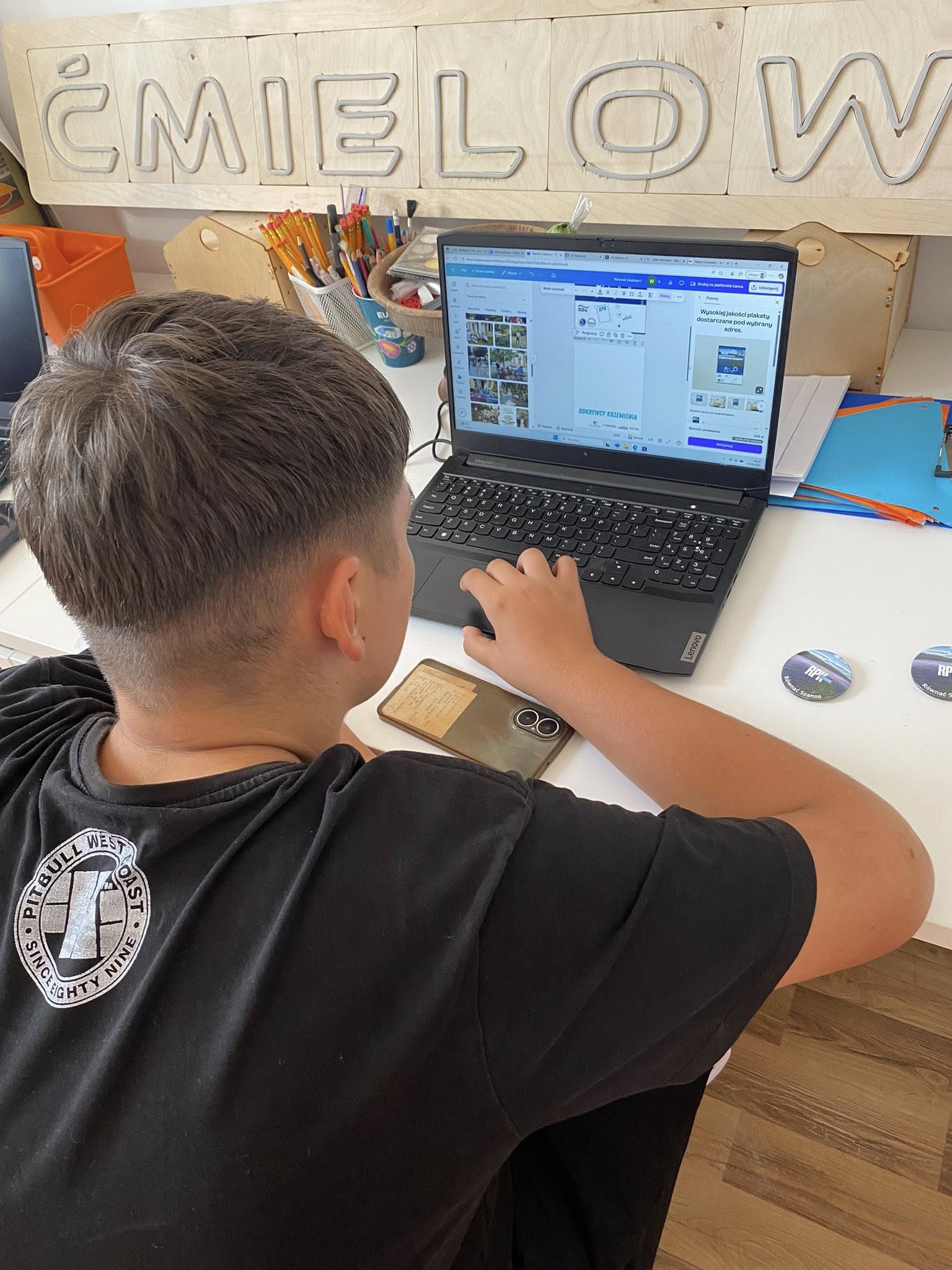 Chłopiec przy laptopie, projektuje nadruk