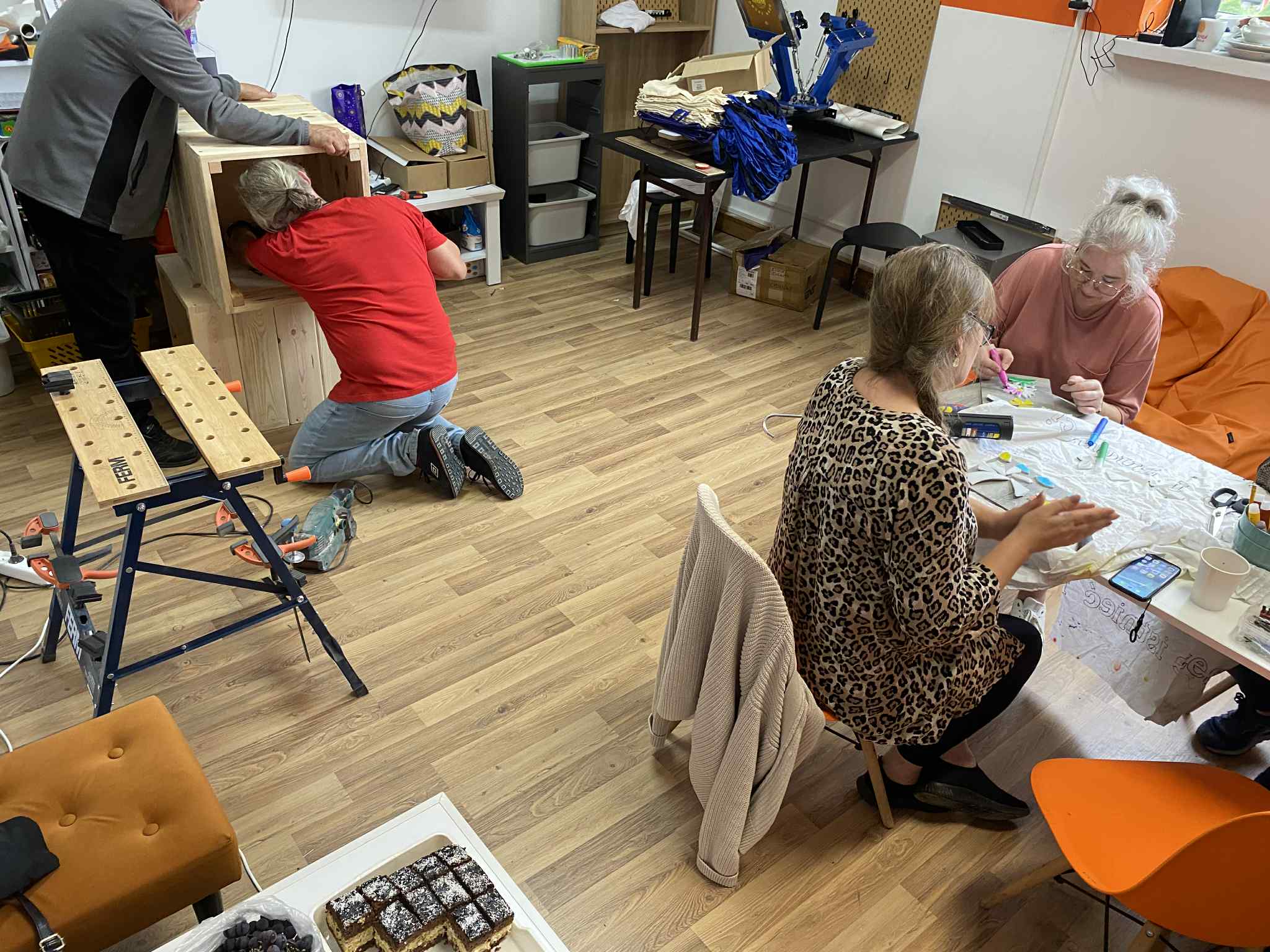 zdjęcie pomieszczenia Pracowni Orange, osoby tworzące mozaikę i doniczki