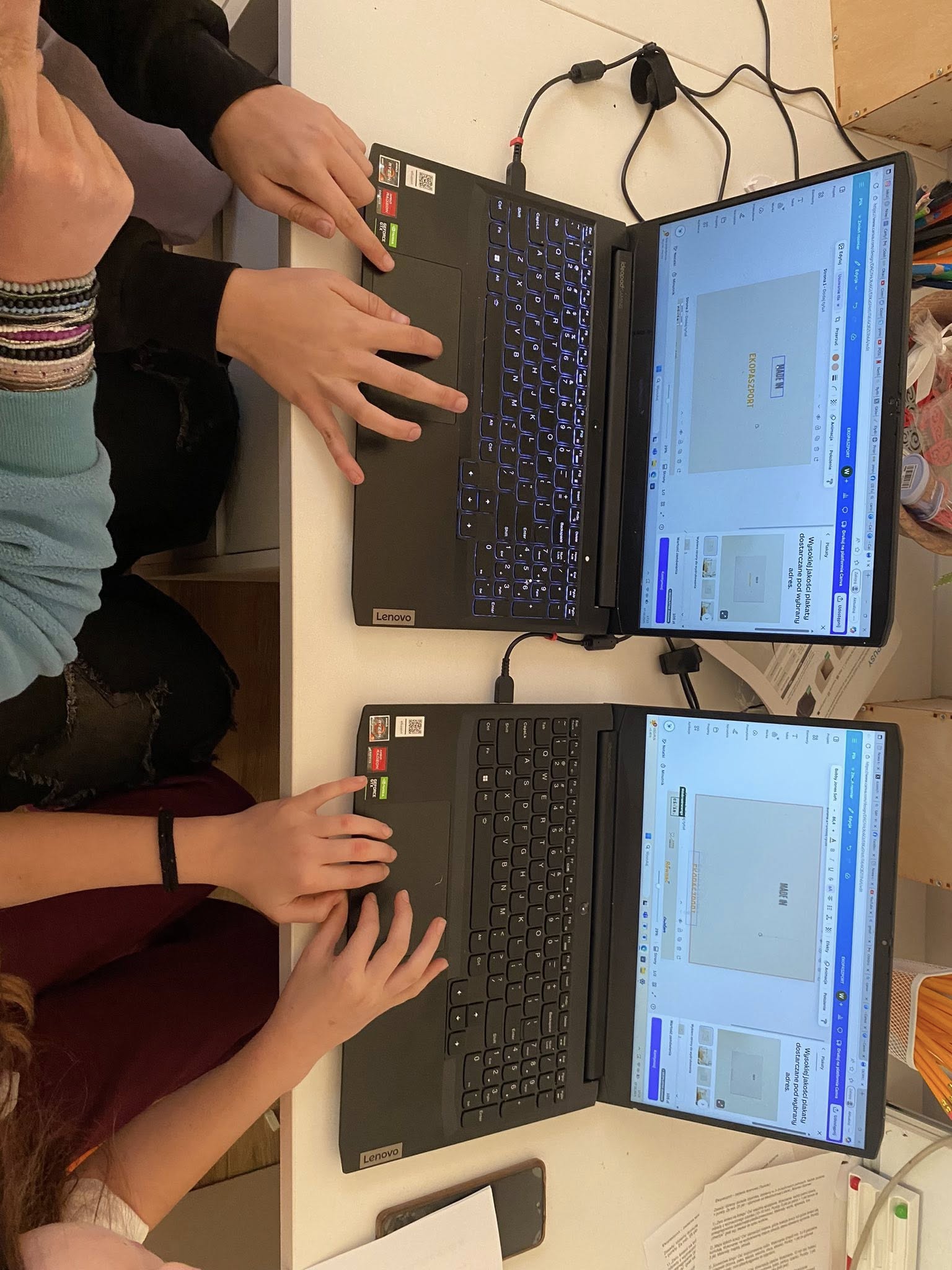 zdjęcie rąk dwójki osób przy laptopie