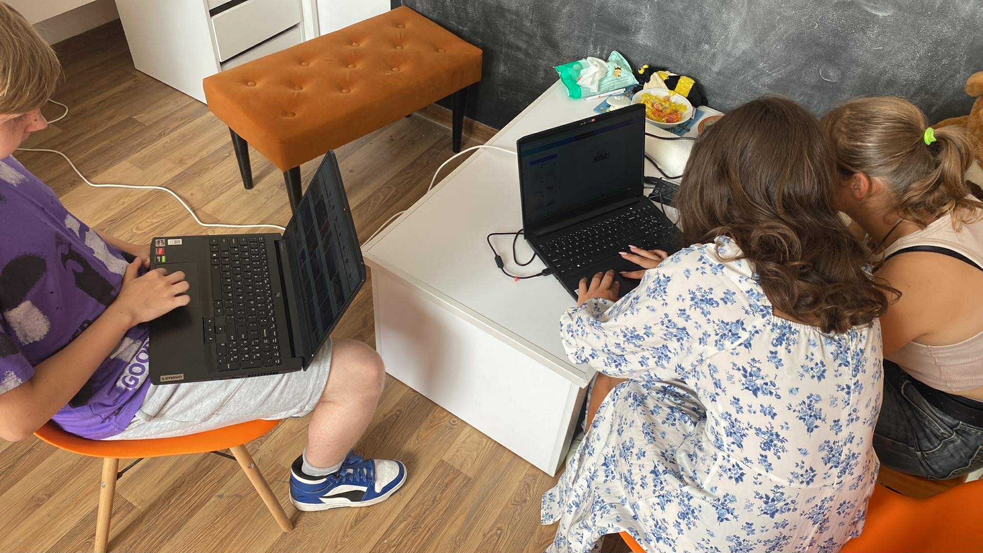 na zdjęciu trzy osoby siedzący przy laptopach