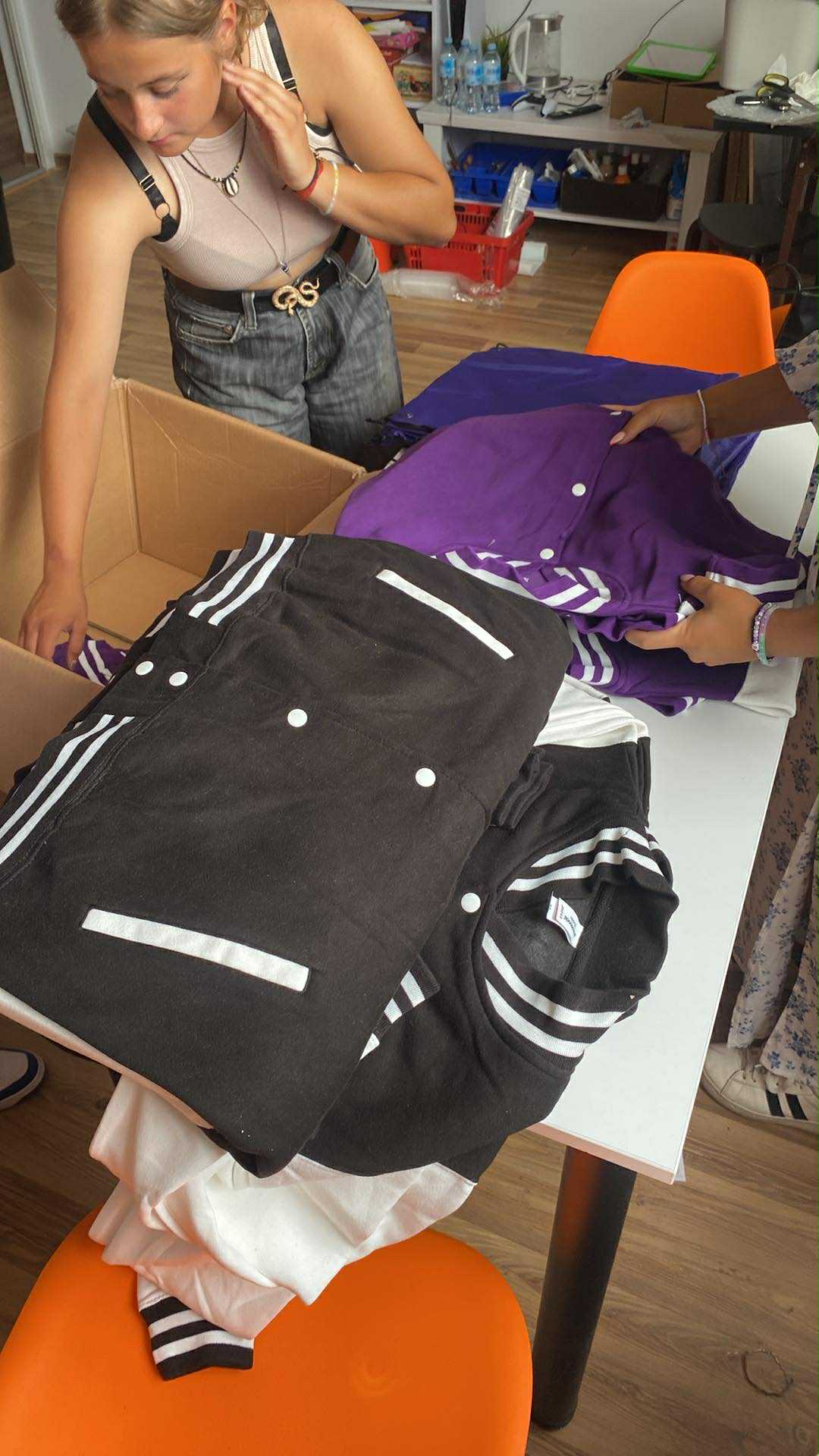 na zdjęciu dziewczyna pakująca bluzy do kartonu