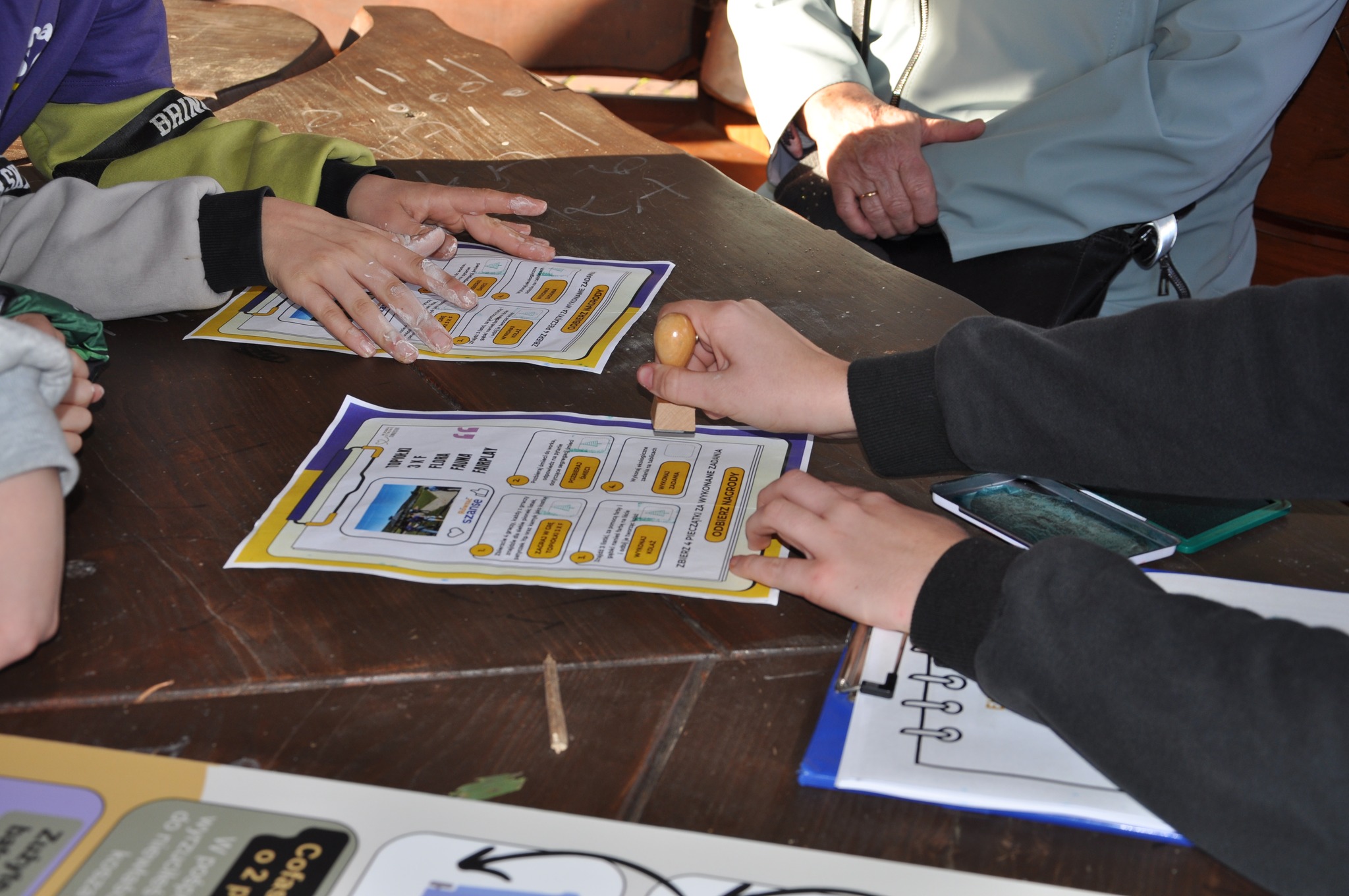 Na zdjęciu widoczna ręka, stemplująca kartę gry 