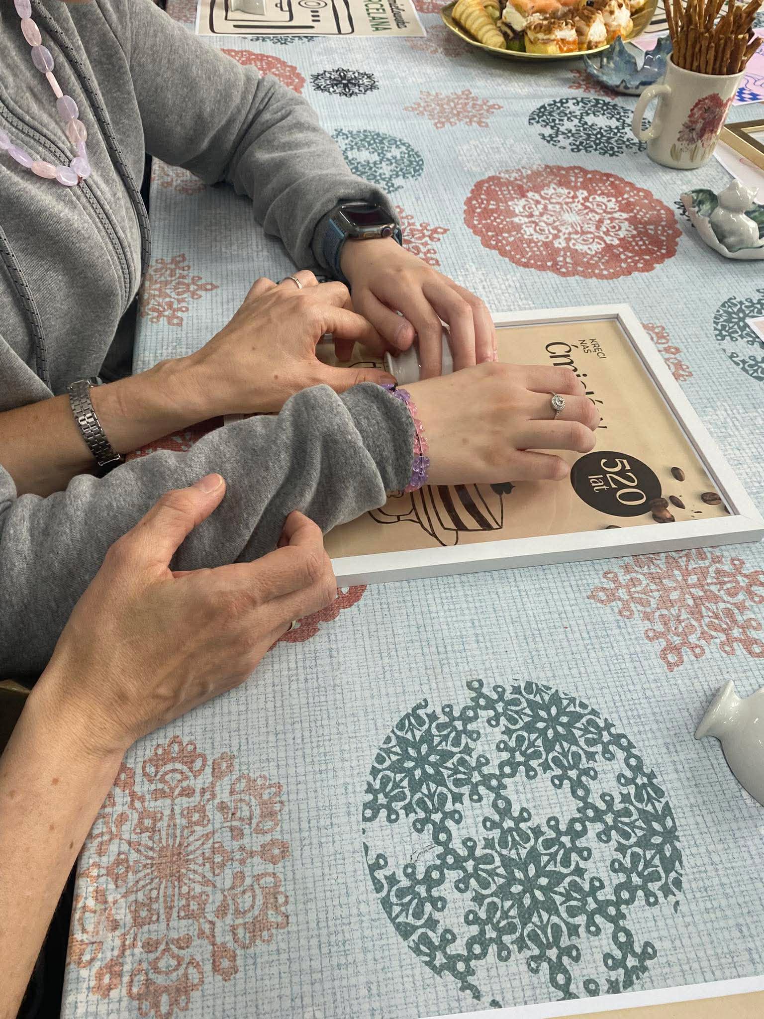 Kadr przedstawiający osoby wykonujące plakaty inspirowane ćmielowską porcelaną.
