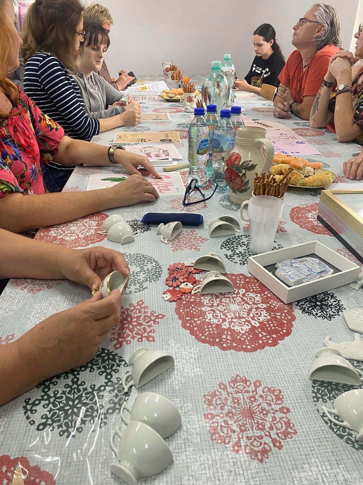 Kadr przedstawiający osoby wykonujące plakaty inspirowane ćmielowską porcelaną.