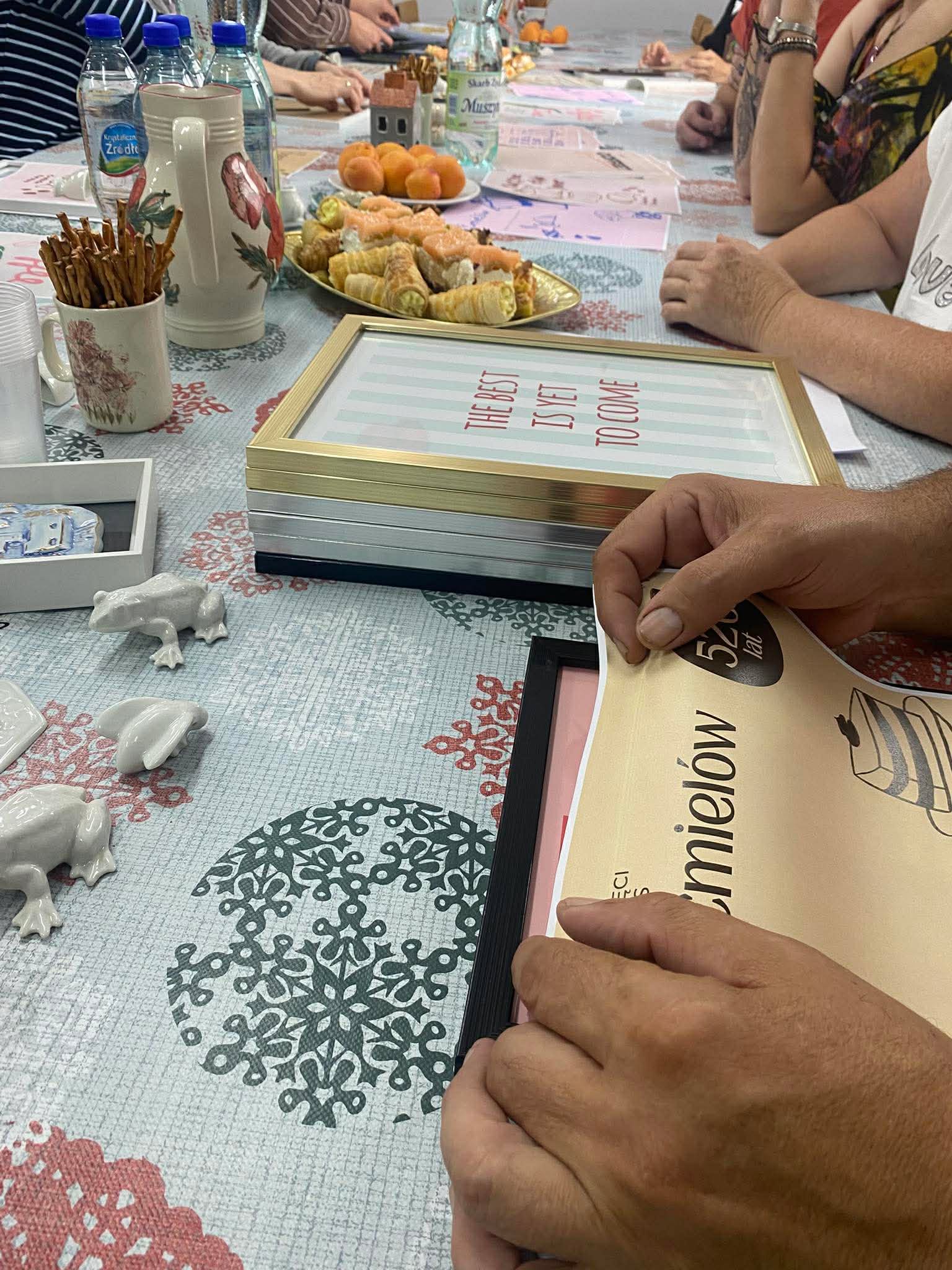 Kadr przedstawiający osoby wykonujące plakaty inspirowane ćmielowską porcelaną.