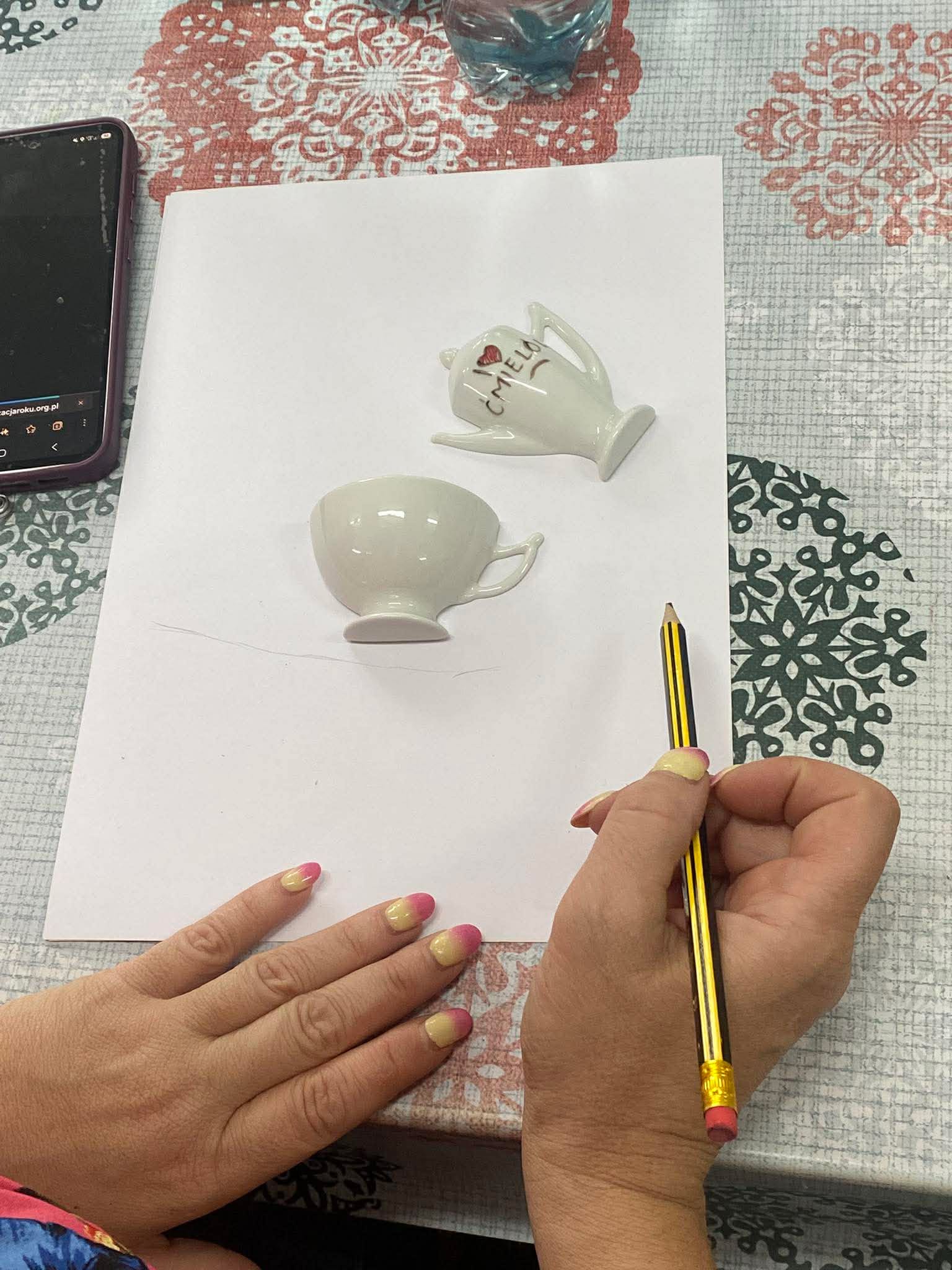 Kadr przedstawiający osoby wykonujące plakaty inspirowane ćmielowską porcelaną.