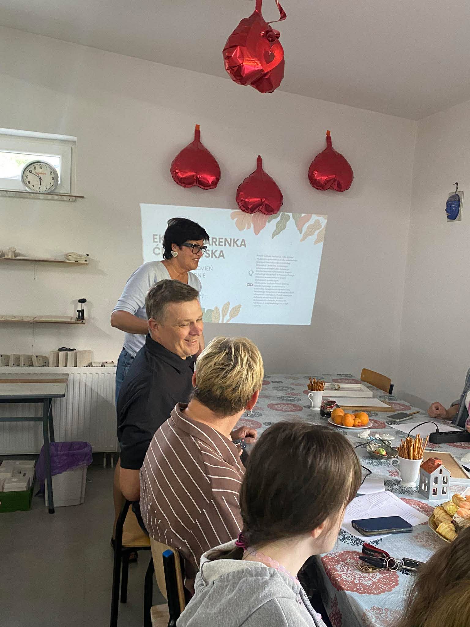 Grupa osób siedzi przy stole podczas warsztatów.