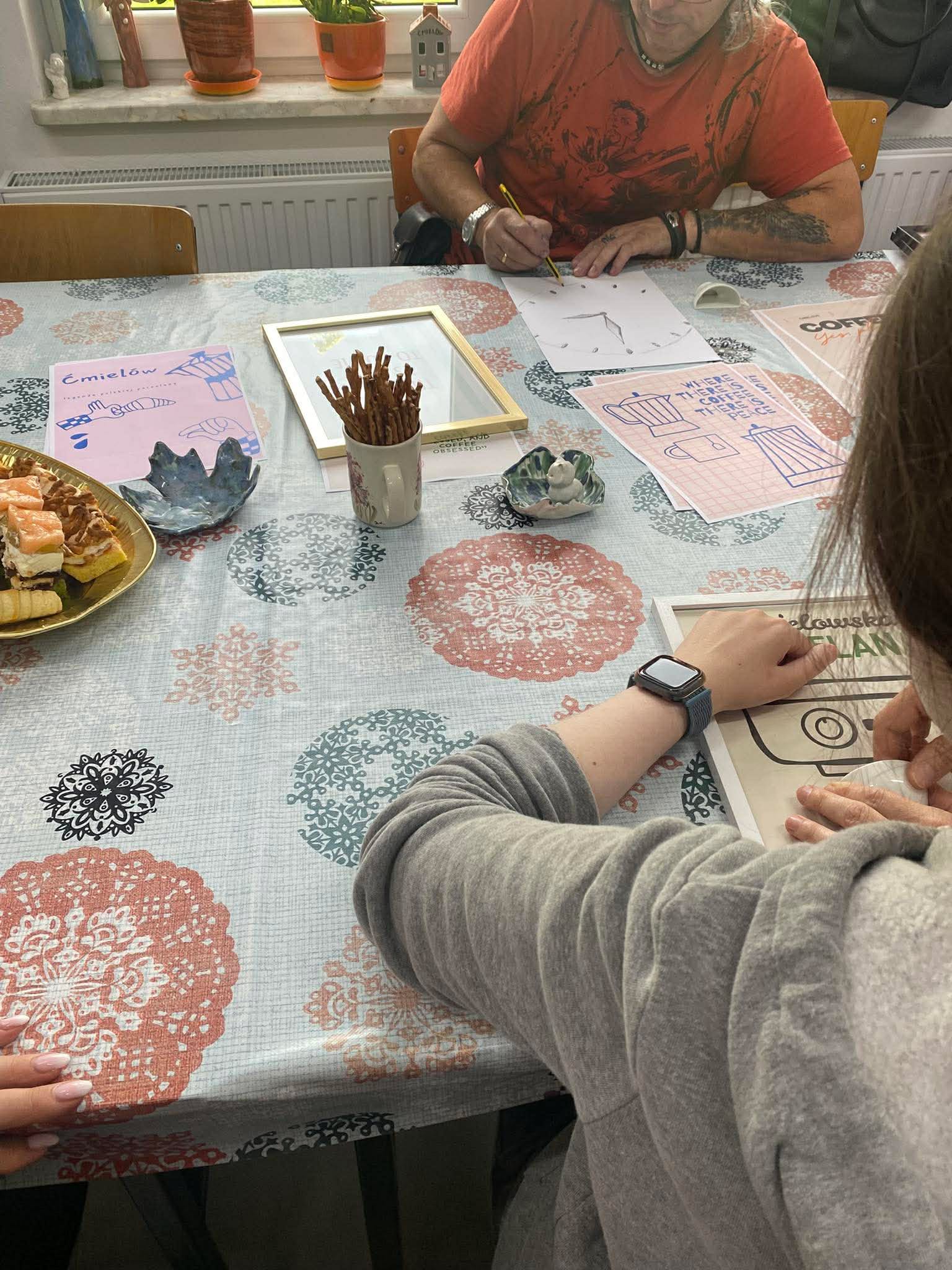 Kadr przedstawiający osoby wykonujące plakaty inspirowane ćmielowską porcelaną.