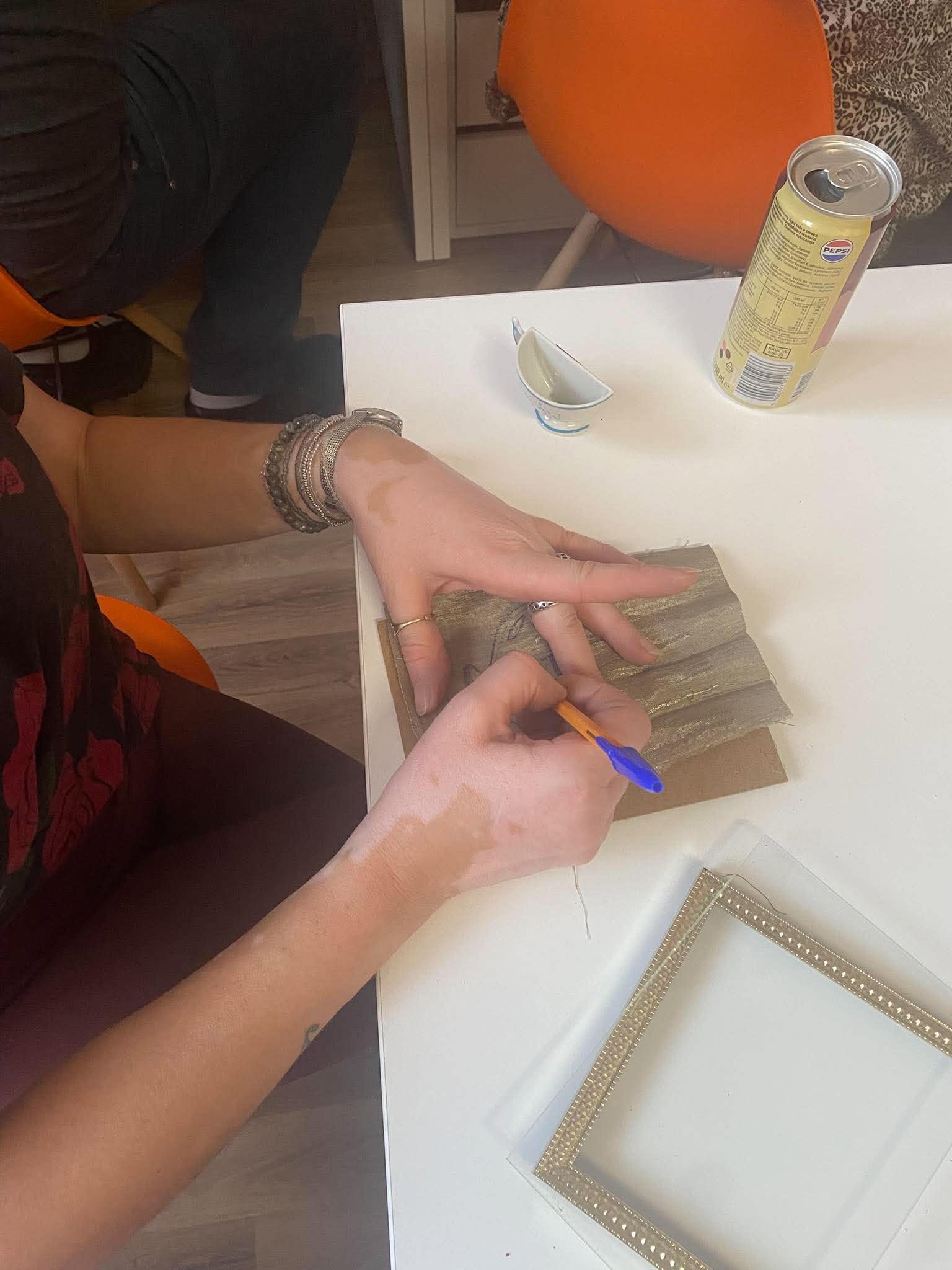 Kobieta ozdabia elementy do ramki.