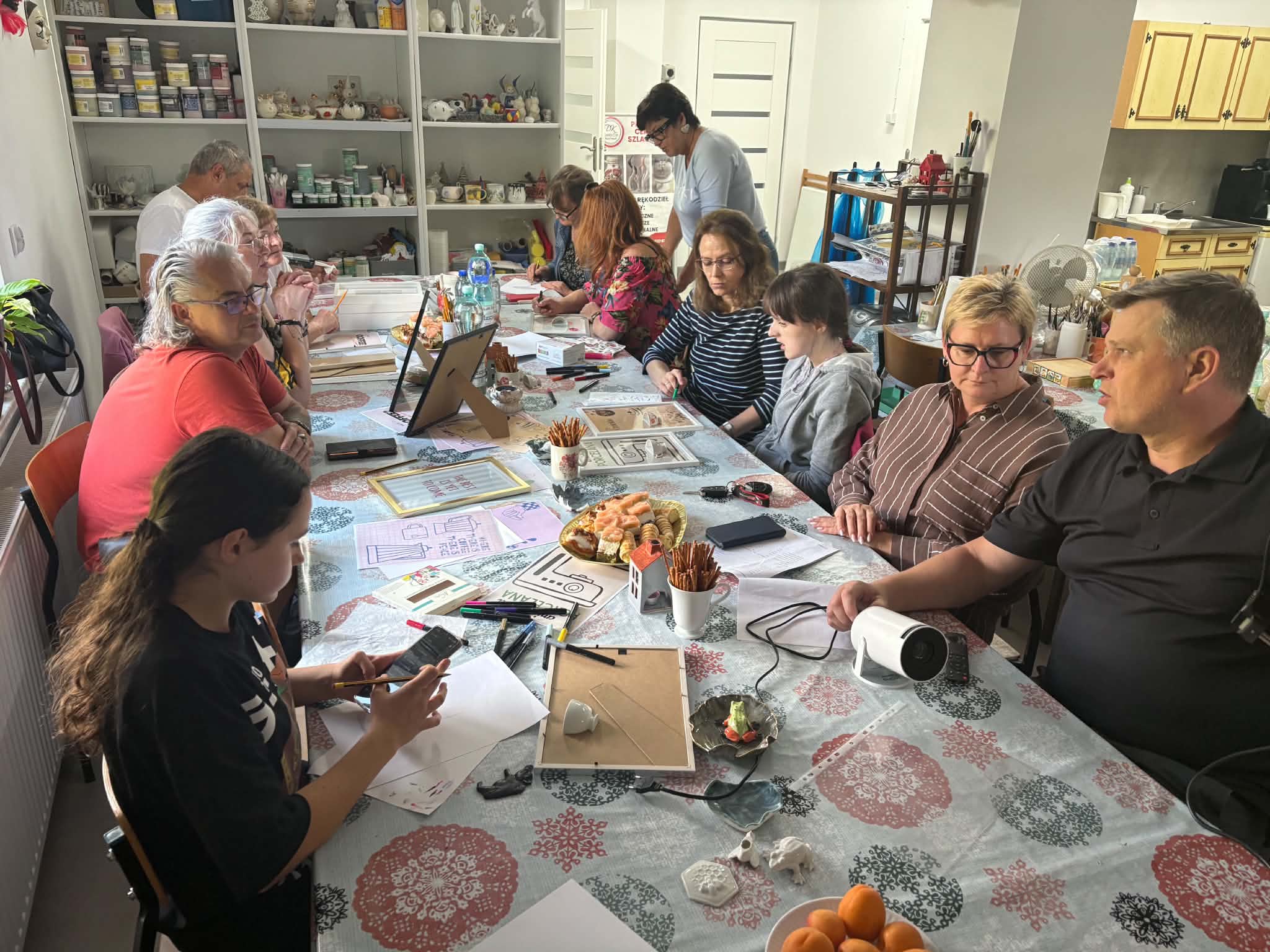 Kadr przedstawiający osoby wykonujące plakaty inspirowane ćmielowską porcelaną.