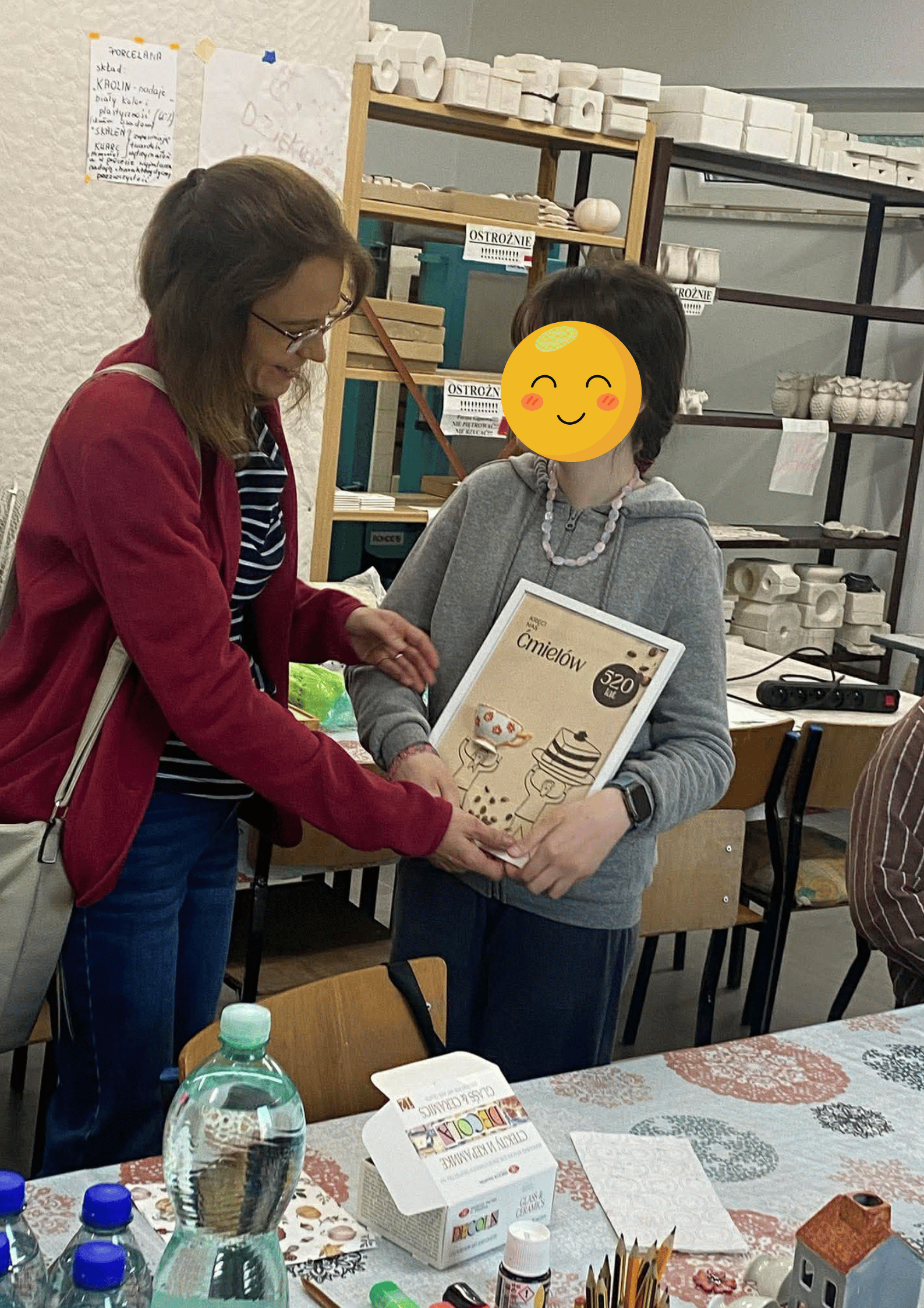 Dziewczyna prezentuje wykonaną przez siebie pracę.