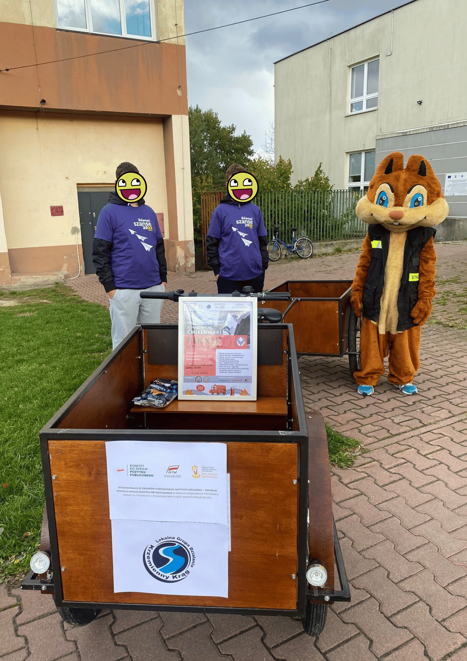 Trzy osoby stoją przy drewnianych wózkach.