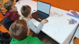 chłopcy siedzący przy laptopie w pracowni orange na zajęciach dotyczących sprzętów cyfrowych