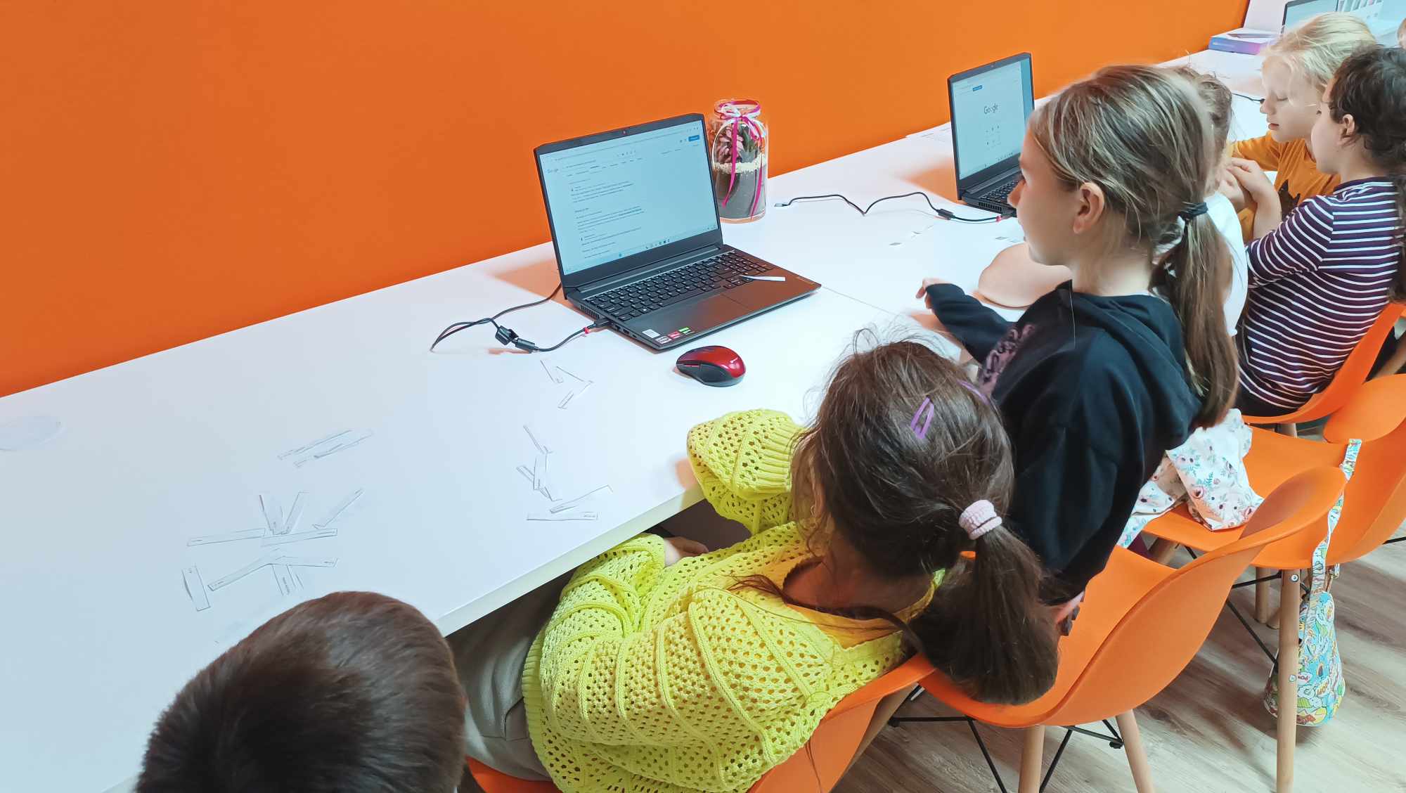 dziewczynki siedzące przy laptopach w pracowni orange