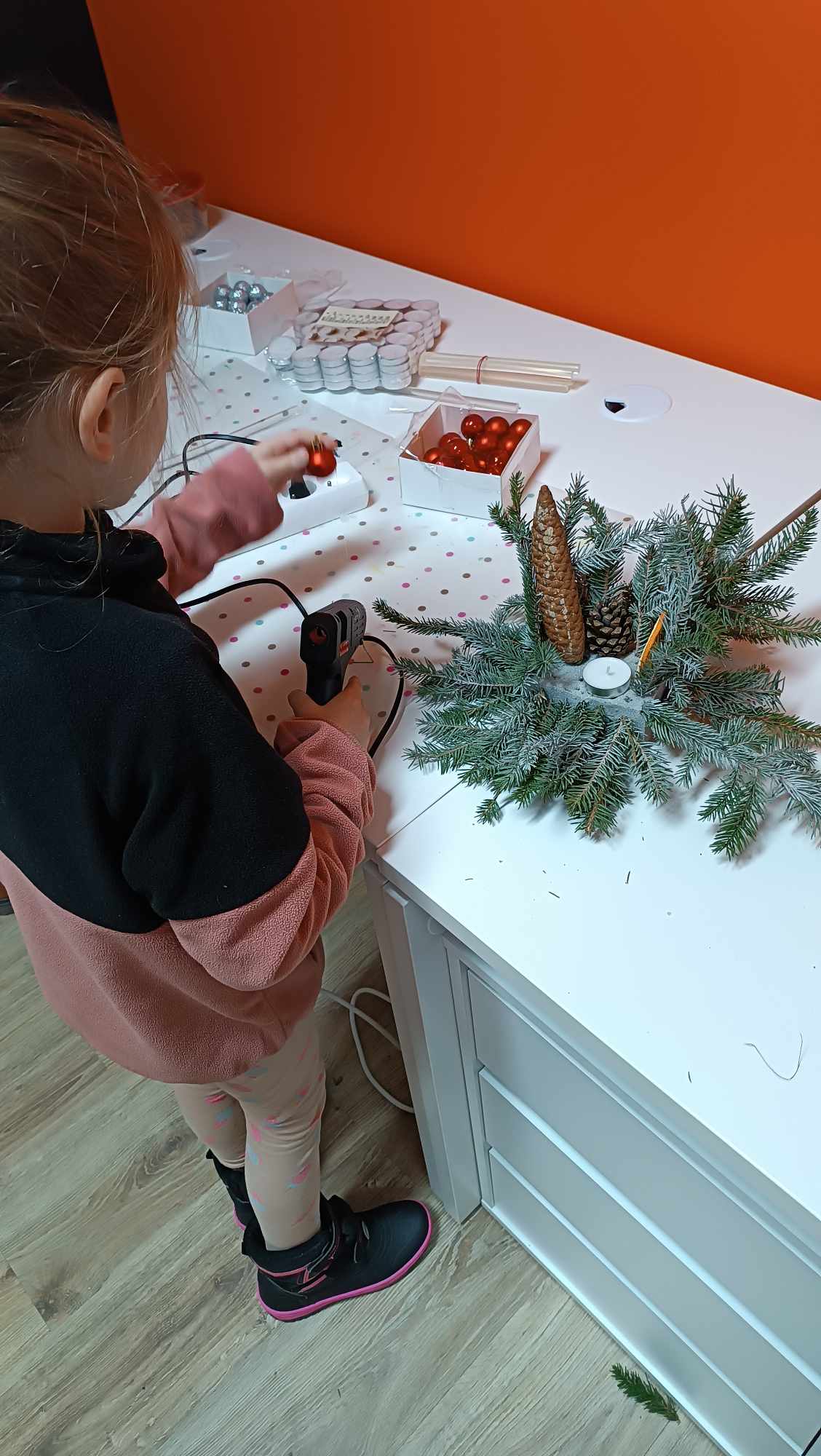 Dziewczynka robi stroik świąteczny.