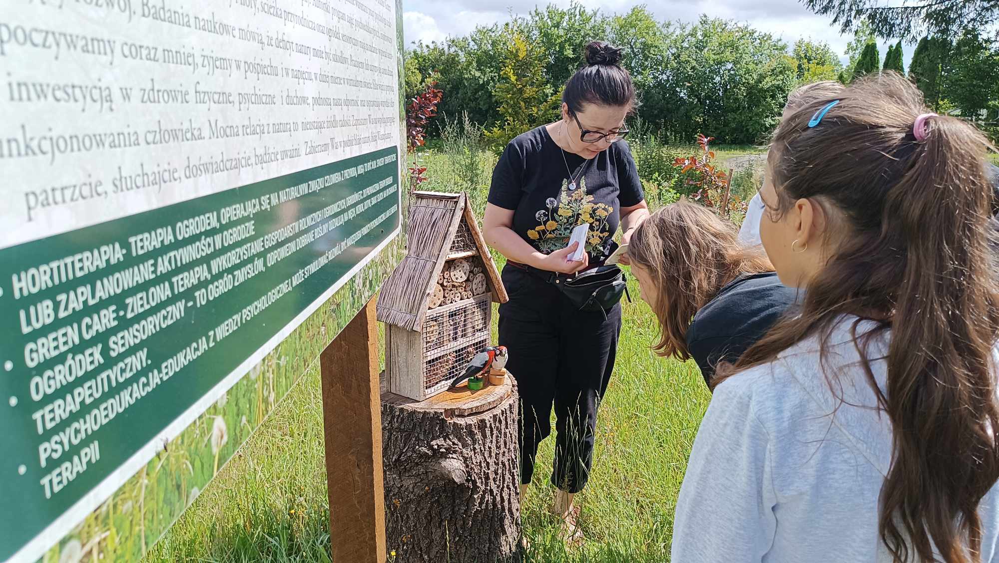 Uczestnicy warsztatów oglądają domek dla owadów.