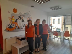 Trzy kobiety stojące obok siebie w Pracowni Orange.