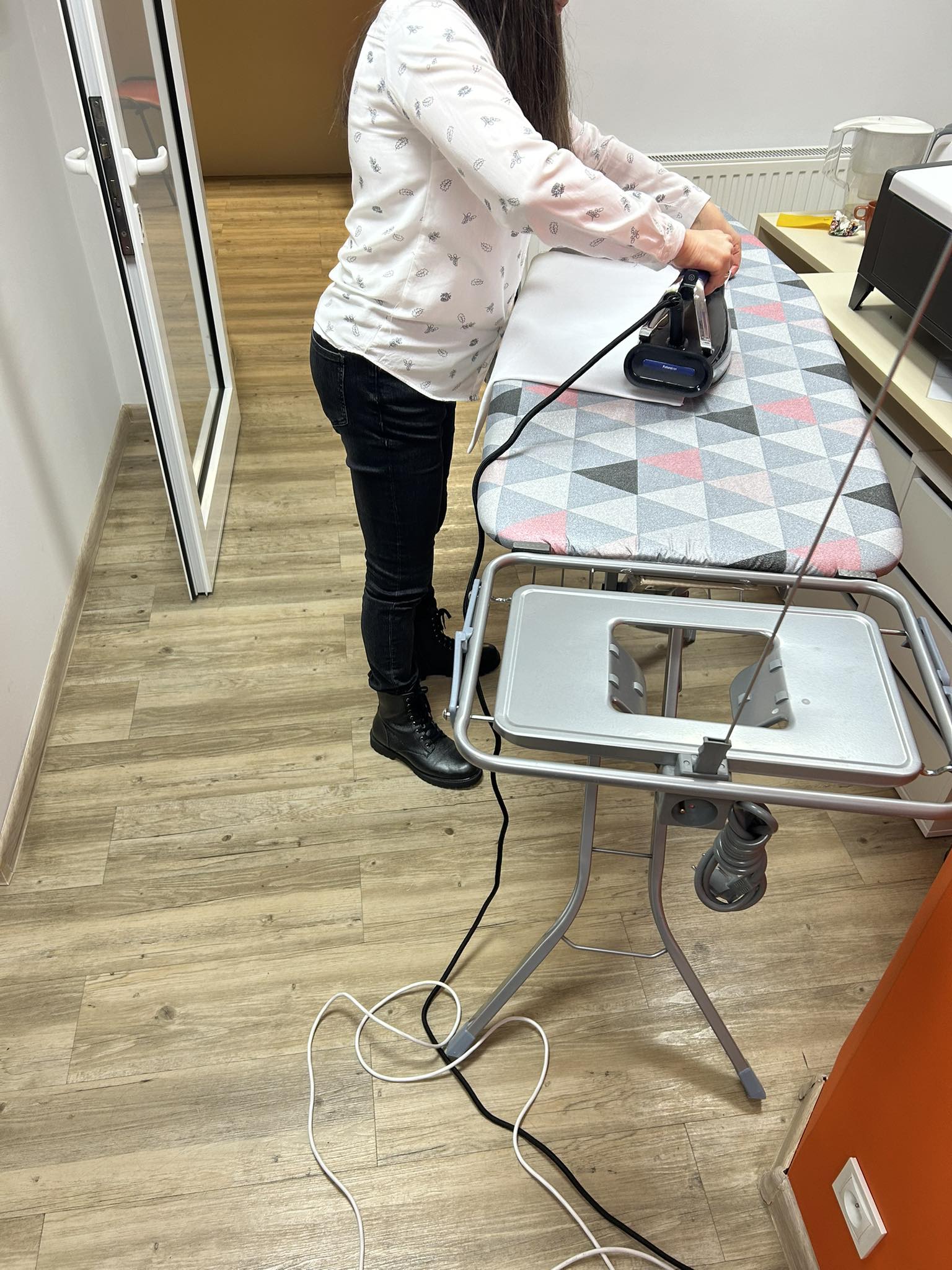 Osoba prasująca materiał.