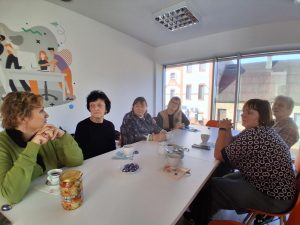 zdjęcie seniorów siedzących przy stole z poczestunkiem