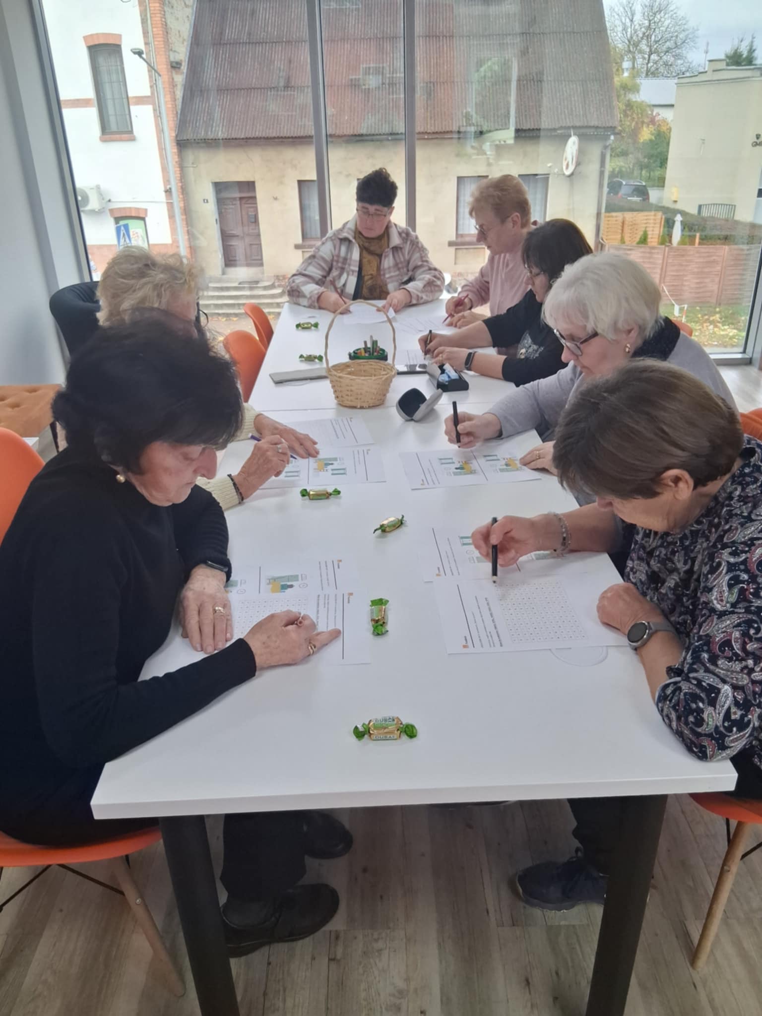 zdjęcie grupy kobiet przy stole notujących na kartkach