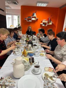 Grupa kobiet siedząca przy wigilijnym stole.