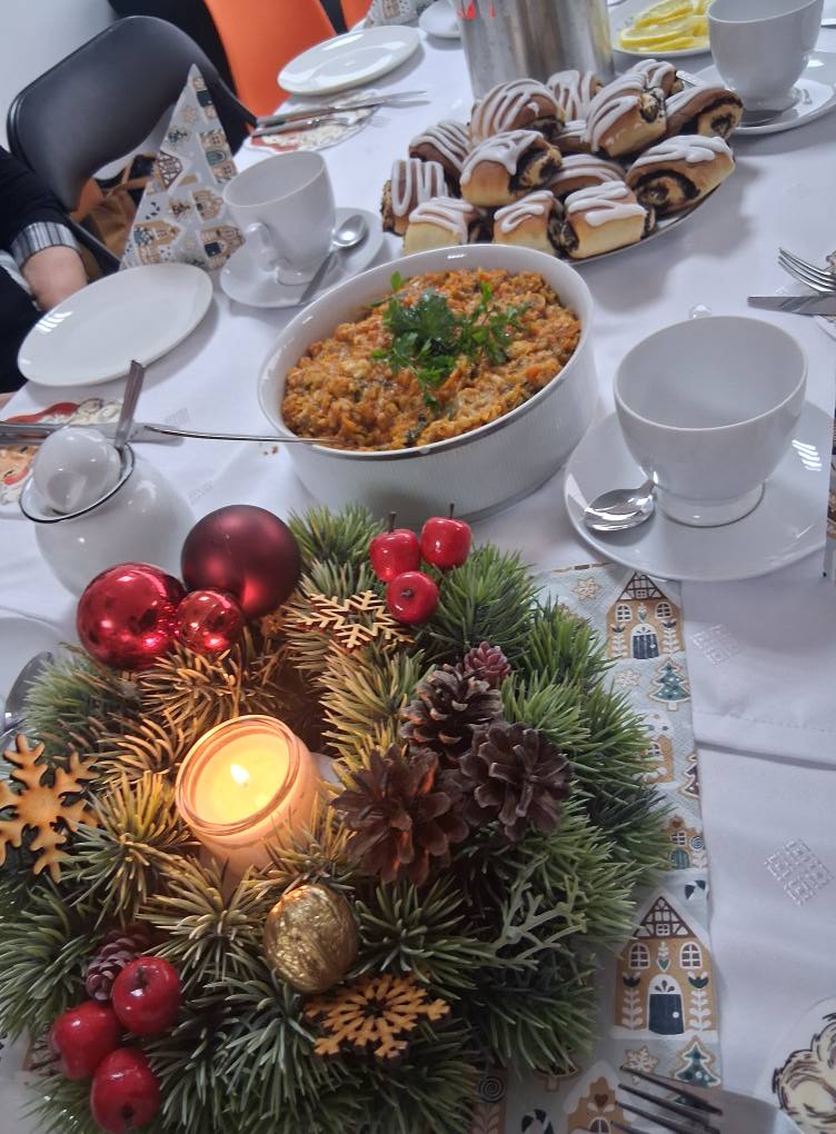 Wieniec świąteczny oraz potrawy wigilijne leżą na stole.