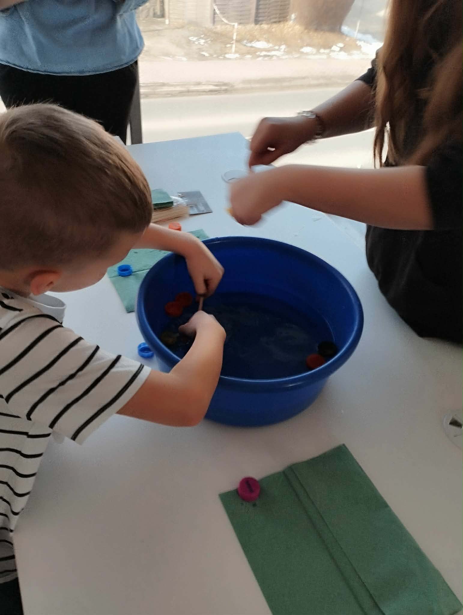 chłopiec próbuje wyłowić nakrętki