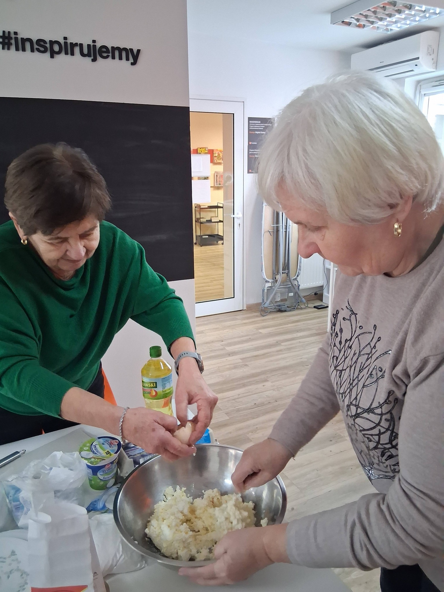 dwie panie przygotowują ciasto na pączki